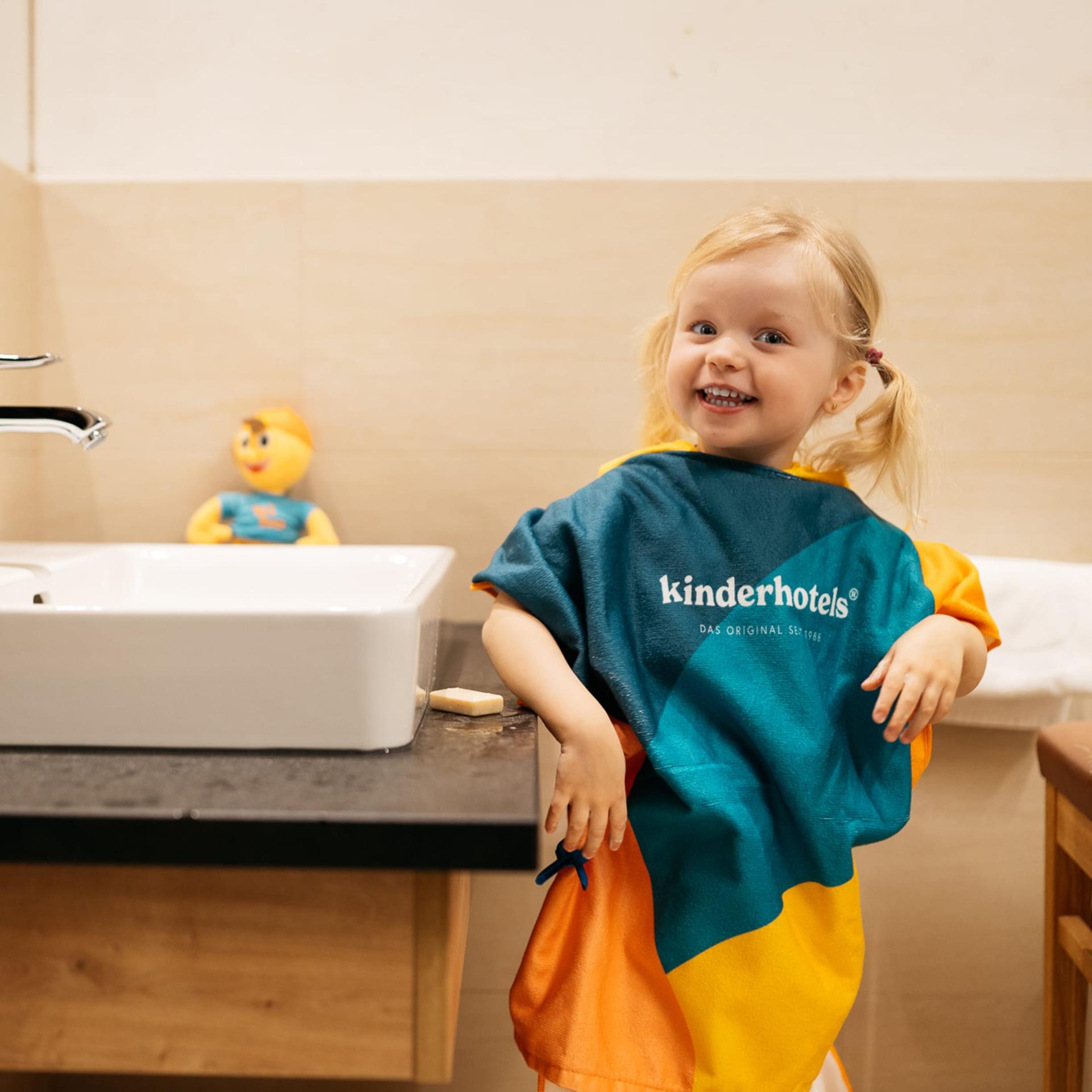 Fröhliches Kind im Badezimmer im Familienresort Buchau