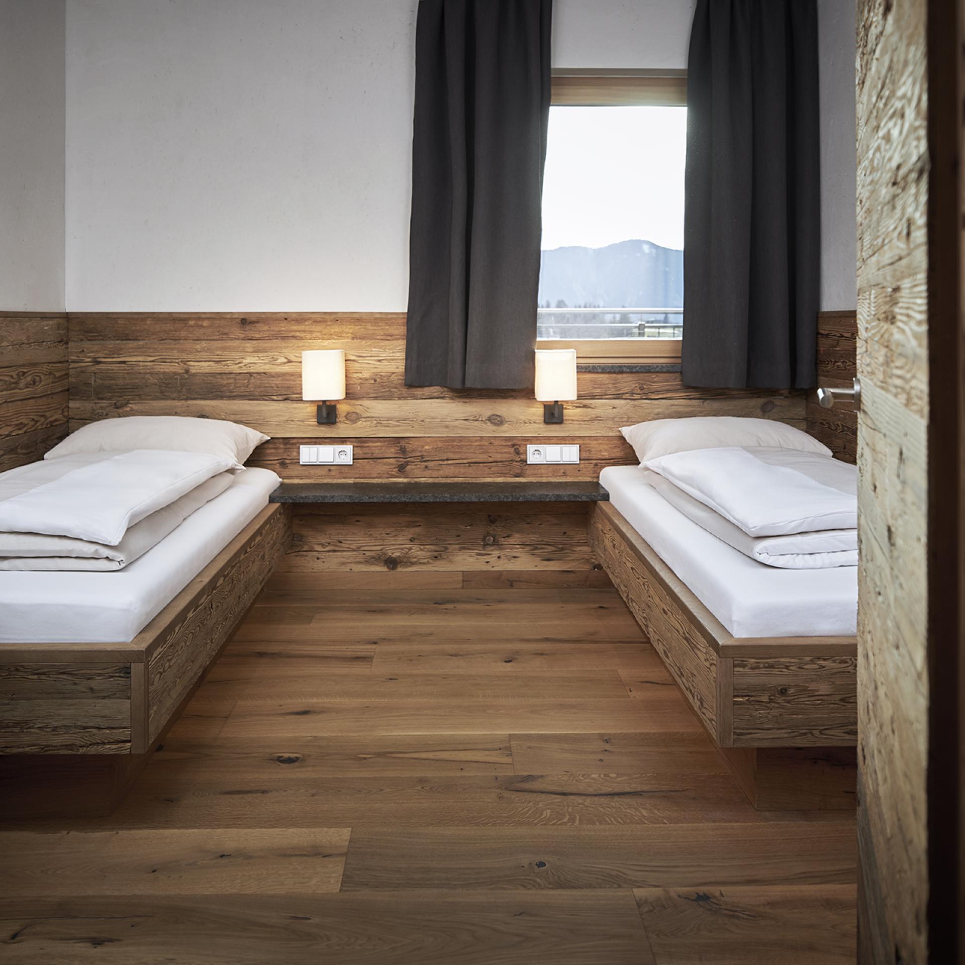 Gemütliches Doppelzimmer im Familienresort Buchau mit Holzdesign und Fensterblick