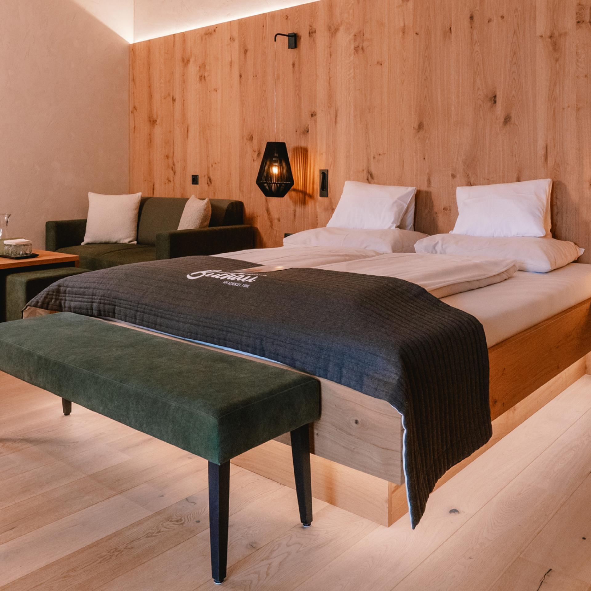Bedroom at Familienresort Buchau with double bed, bench and wooden walls