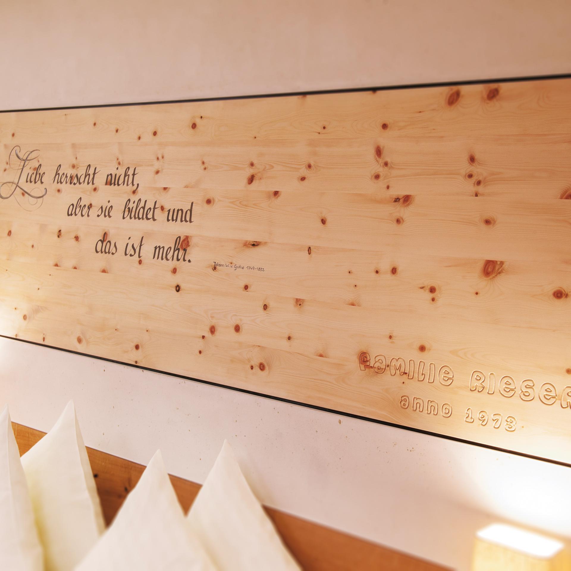 Wood decoration in Familienresort Buchau with the quote Love does not reign but forms.
