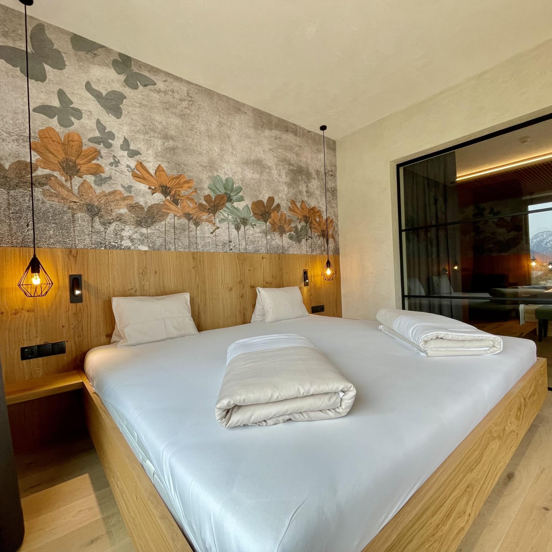 Modernes Schlafzimmer im Familienresort Buchau mit Doppelbett und Blumendekor