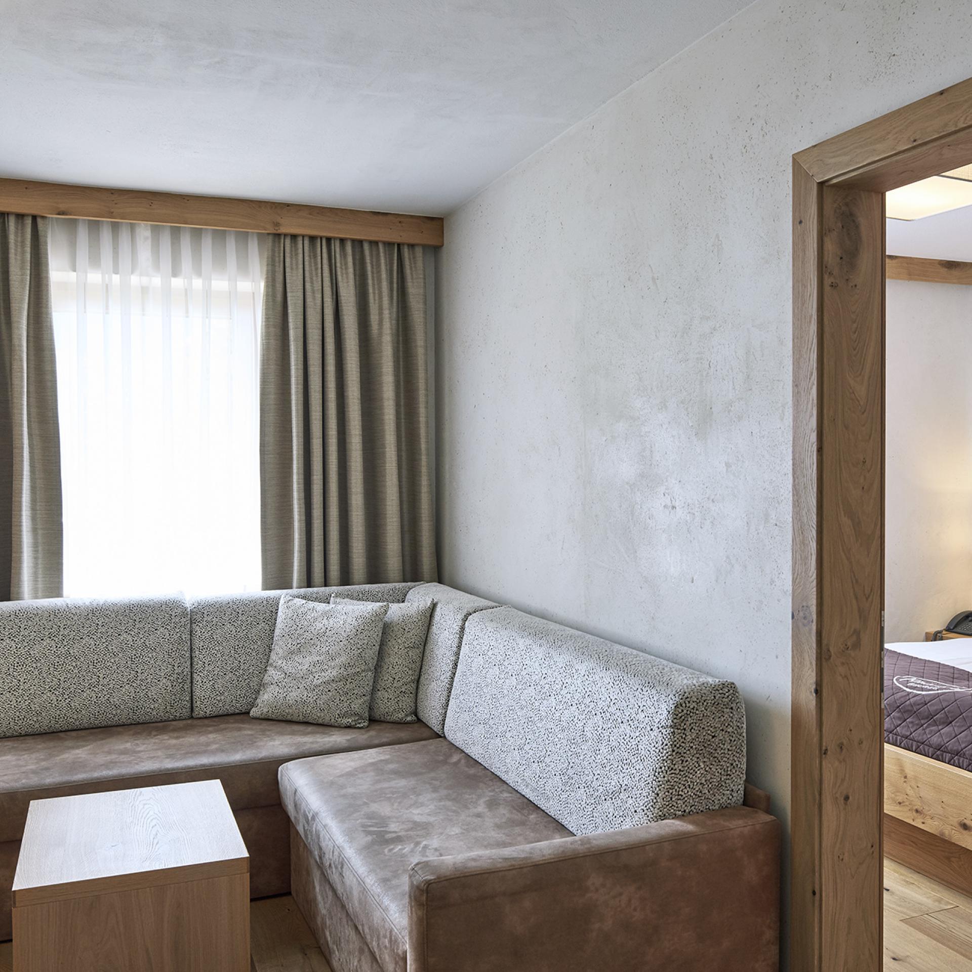 Hell eingerichtetes Schlafzimmer im Familienresort Buchau mit großen Fenstern und modernem Design