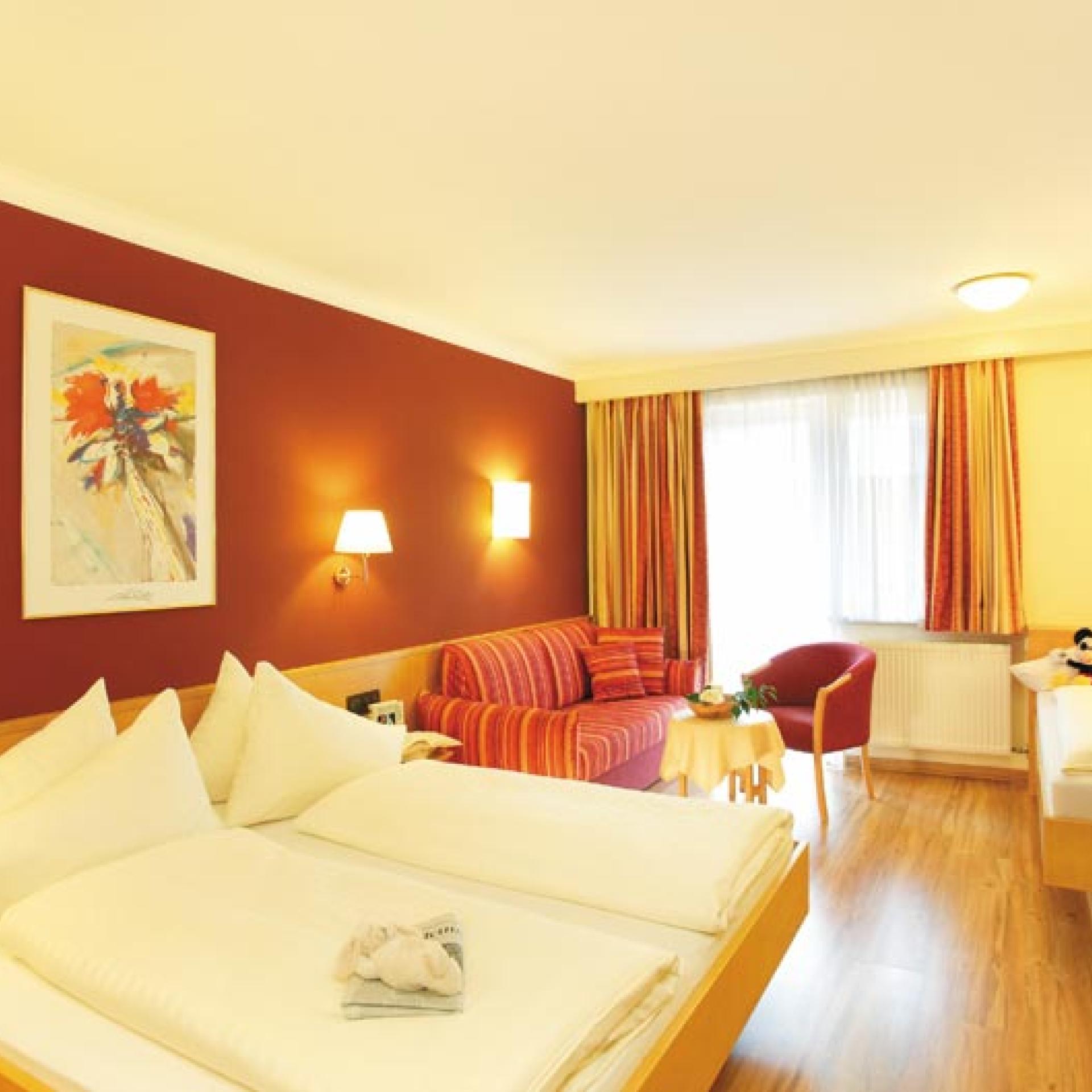 Gemütliches Familienzimmer im Familienresort Buchau mit Doppel- und Einzelbett.
