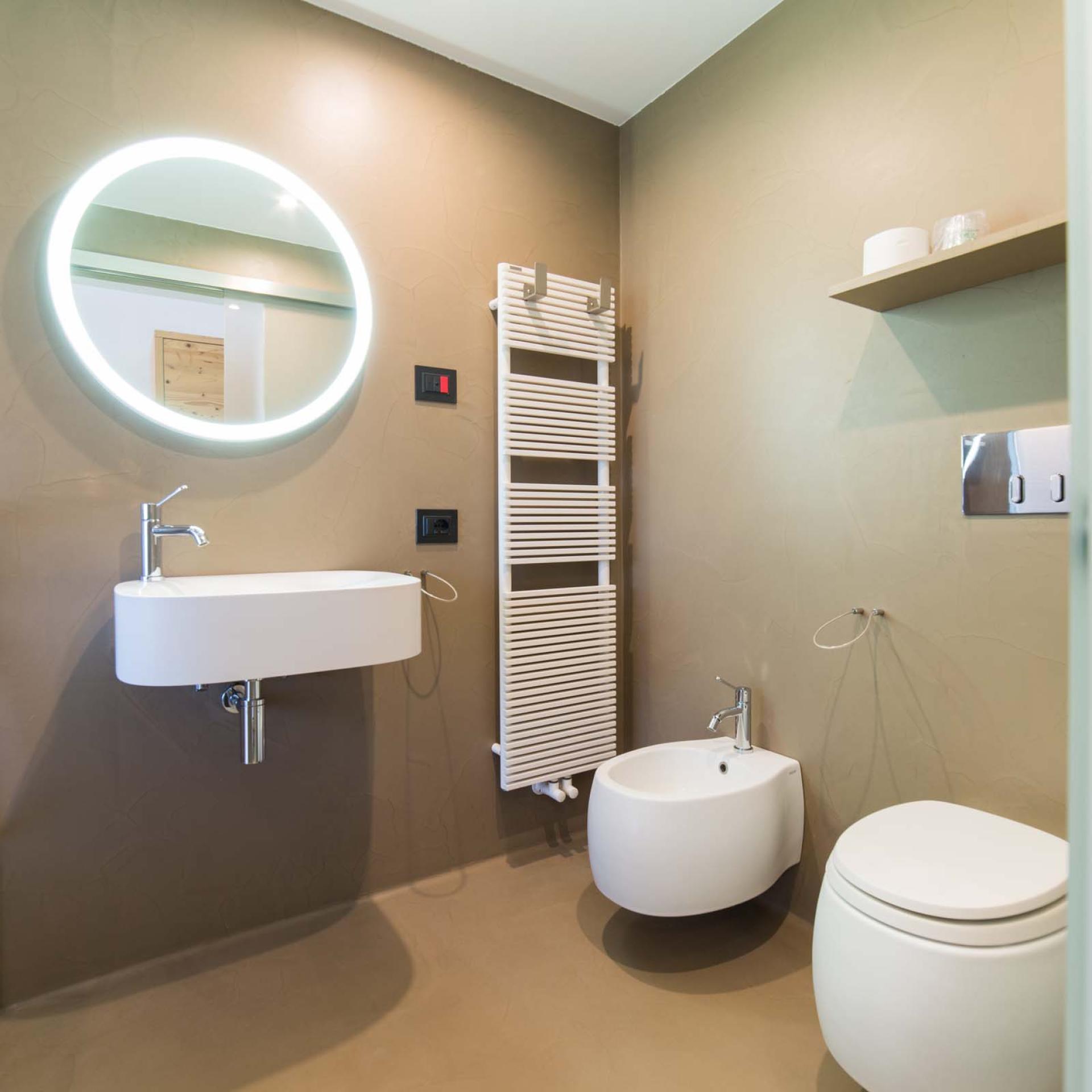 Bagno moderno all'Hotel San Giacomo con lavabo, WC e specchio illuminato