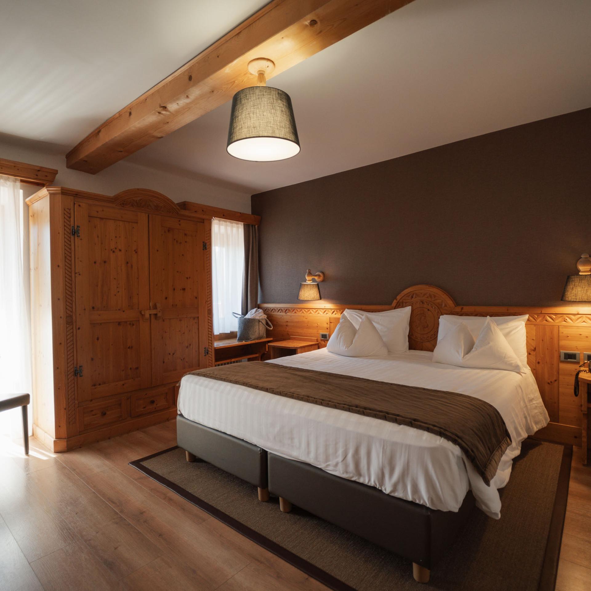 Letto accogliente con cuscini nella camera dell'Hotel San Giacomo
