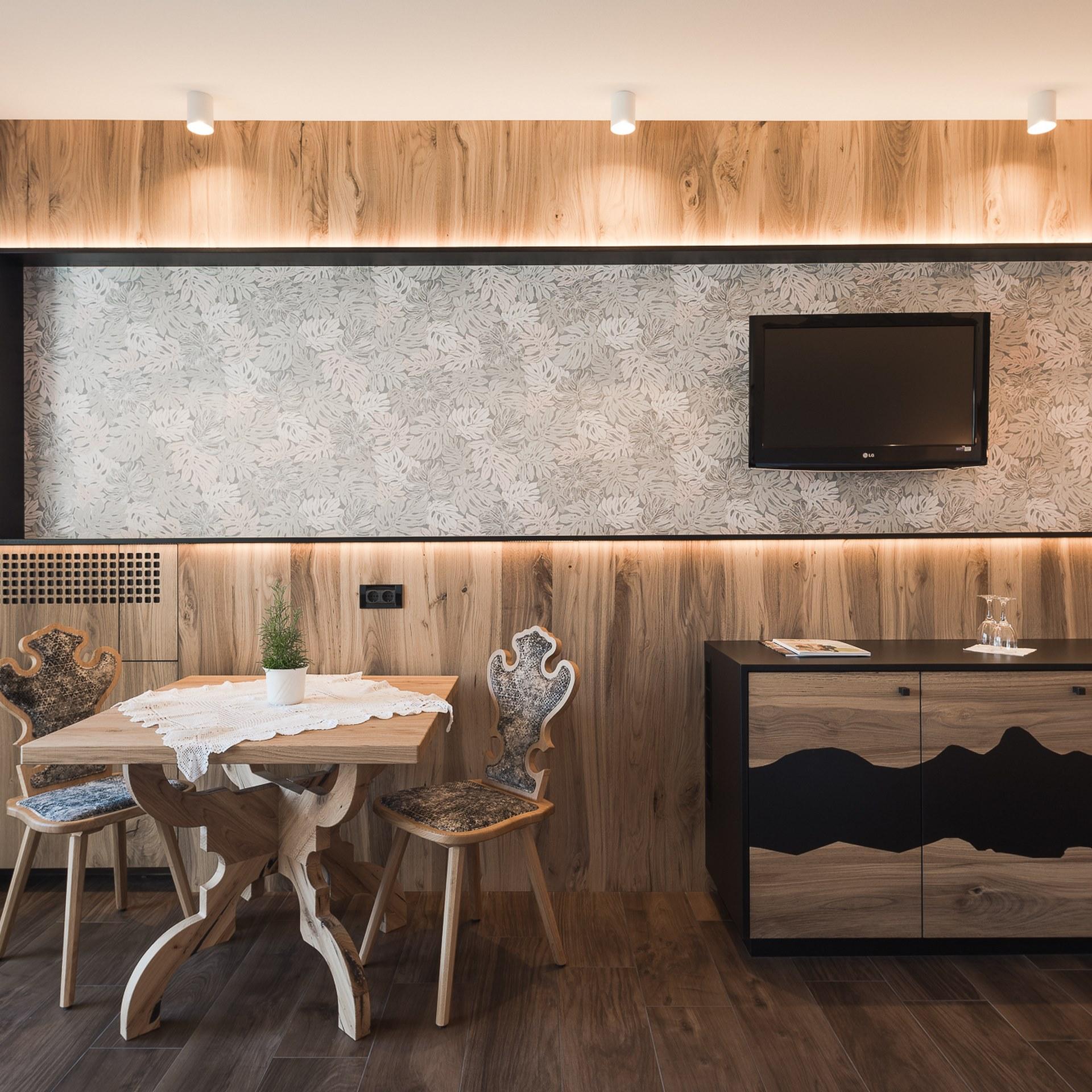 Eleganter Essbereich im Alpenpalais Kröll mit Holzmöbeln und modernem Design