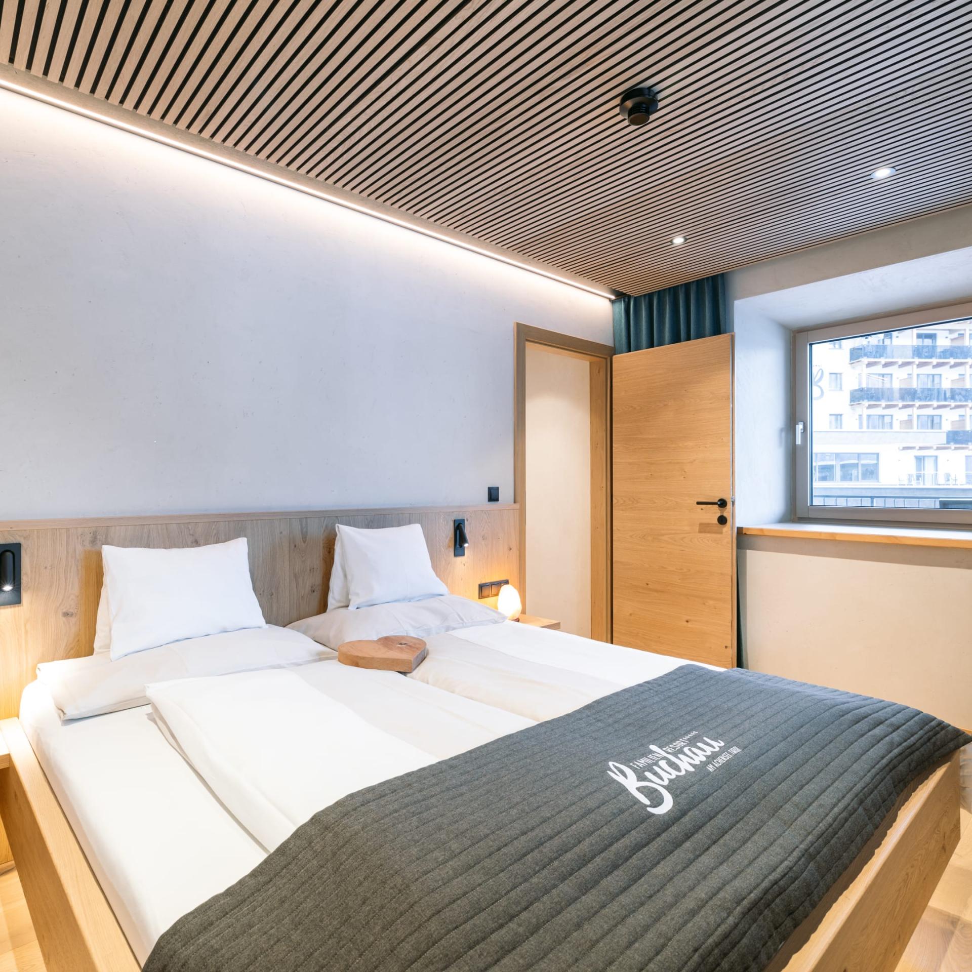 Modern double room at Familienresort Buchau with wooden furniture and window view