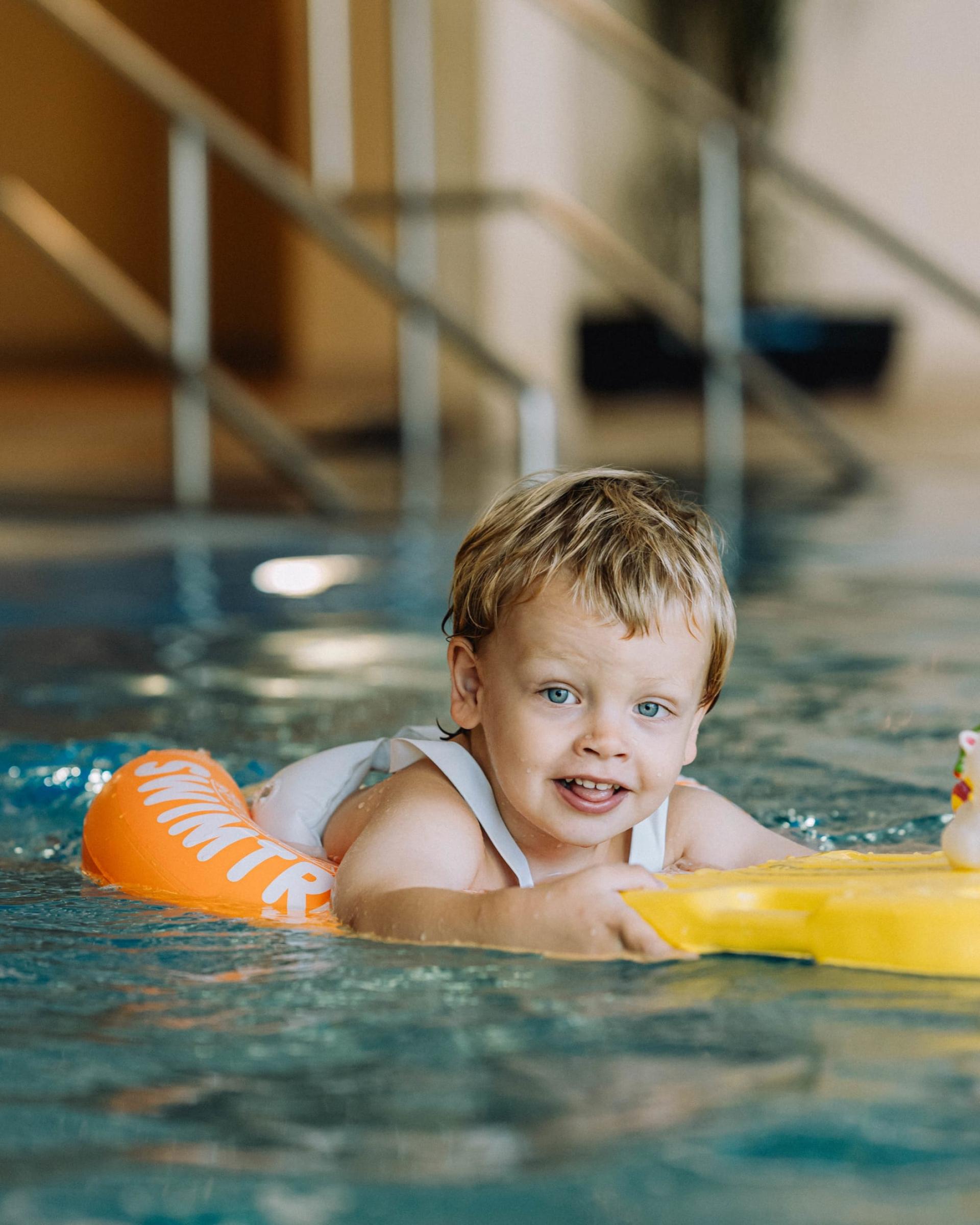 Kleiner Junge schwimmt im Familienresort Buchau mit Spielzeug im Pool