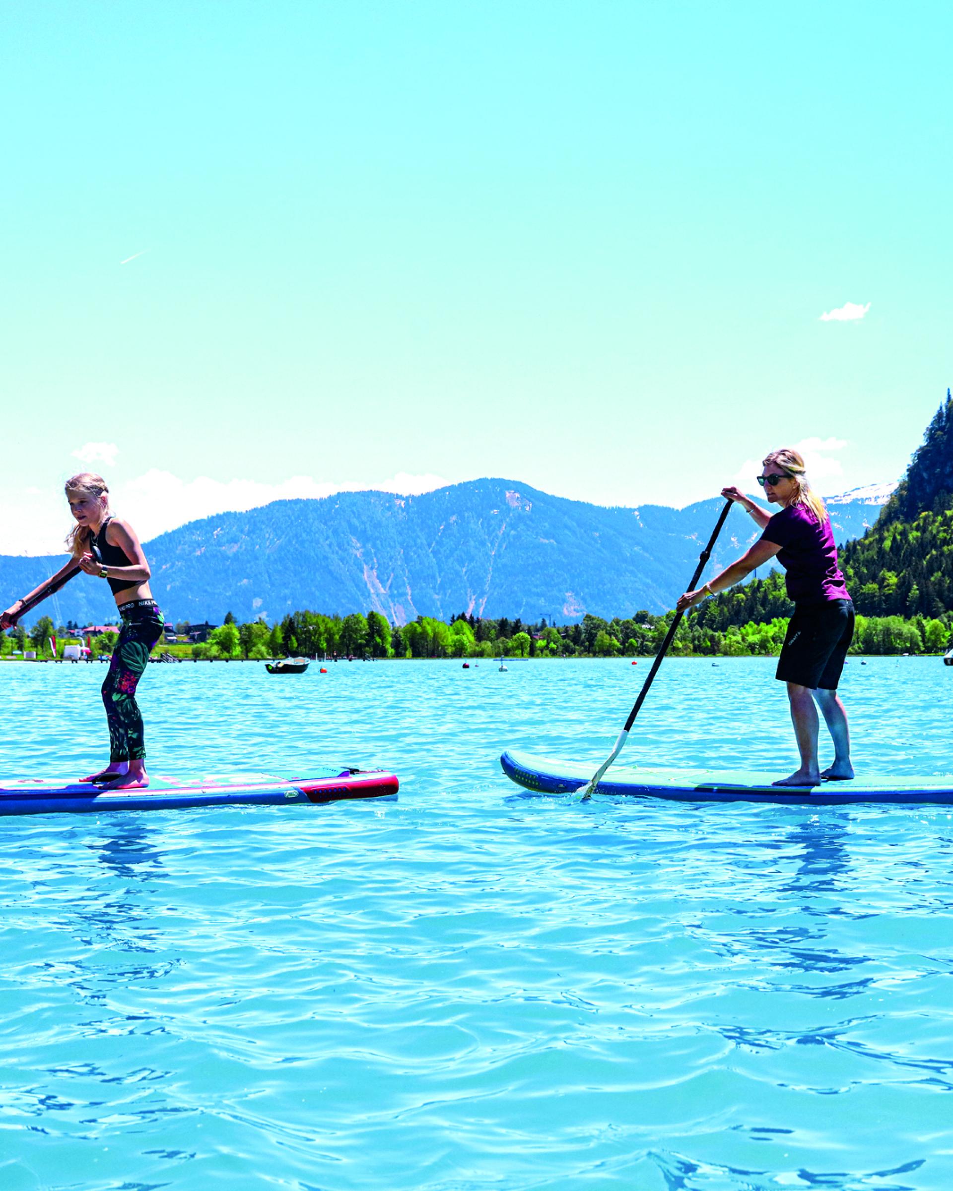 Zwei Personen paddeln auf Stand-Up-Paddle-Boards am Familienresort Buchau