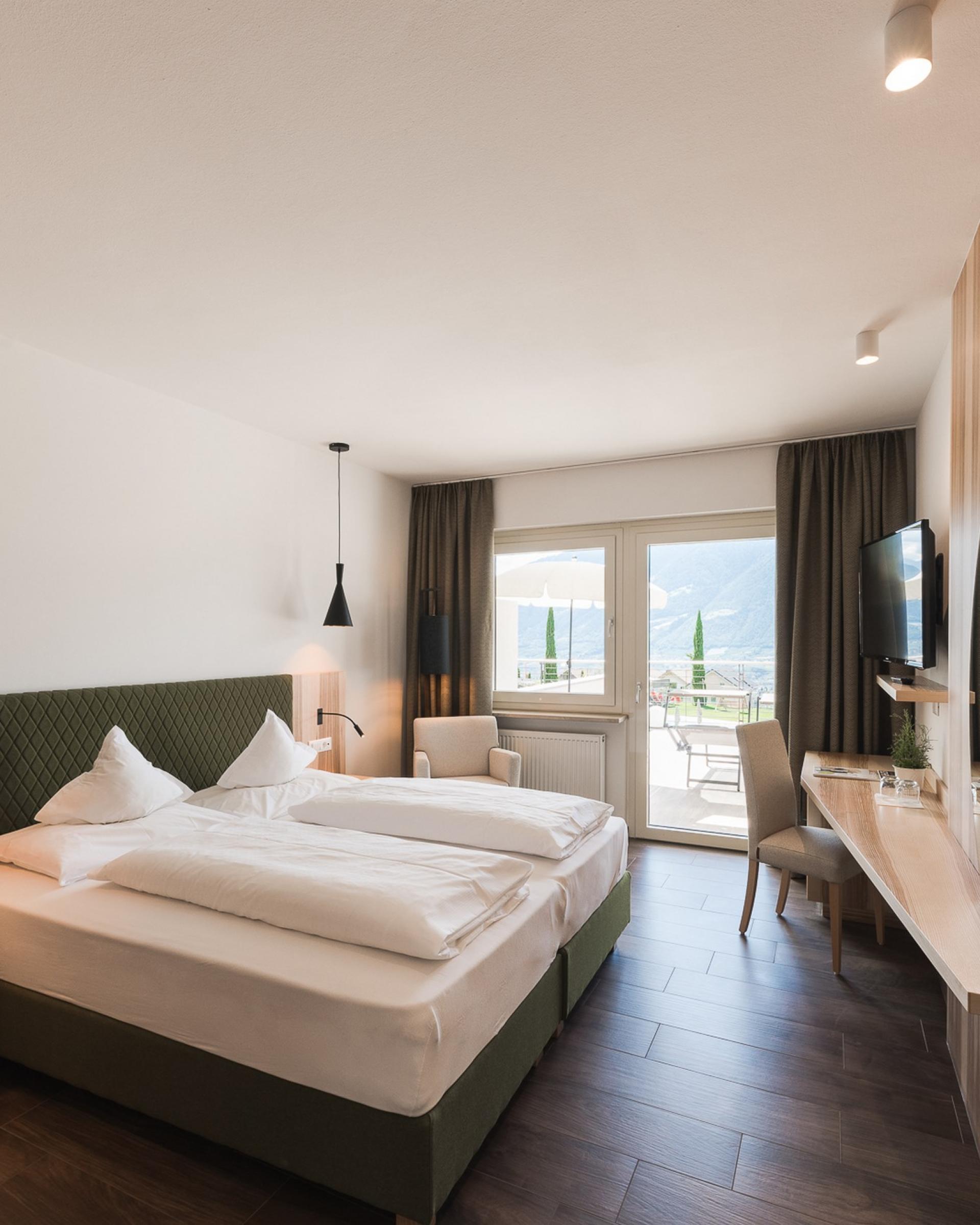 Modernes Schlafzimmer im Alpenpalais Kröll mit Balkon und Bergblick