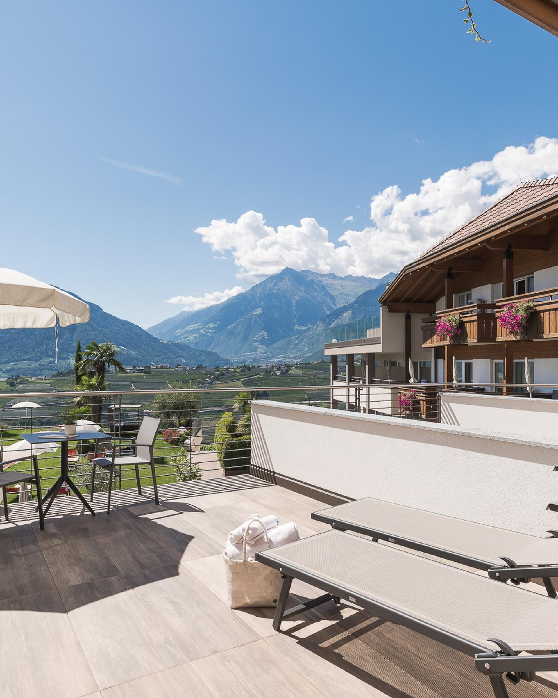 Terrasse mit Liegestühlen und Alpenpalais Kröll im Hintergrund