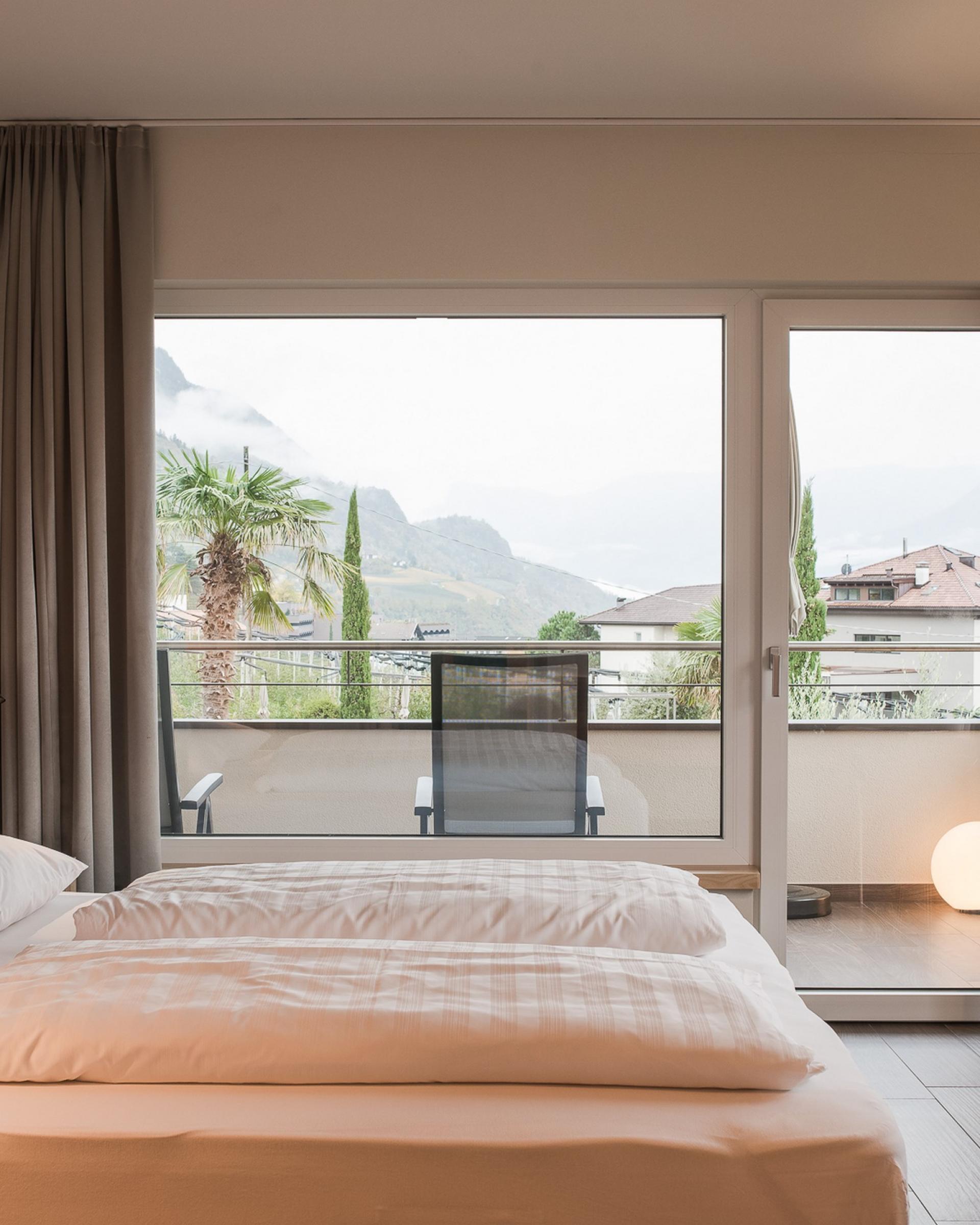 Hell eingerichtetes Zimmer mit Balkon und Bergblick im Alpenpalais Kröll