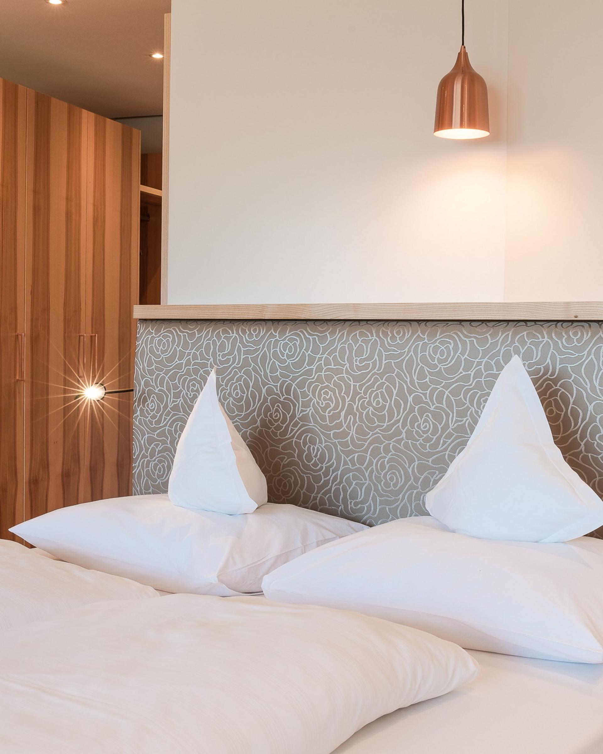 Gemütliches Schlafzimmer im Alpenpalais Kröll mit modernem Holzdekor