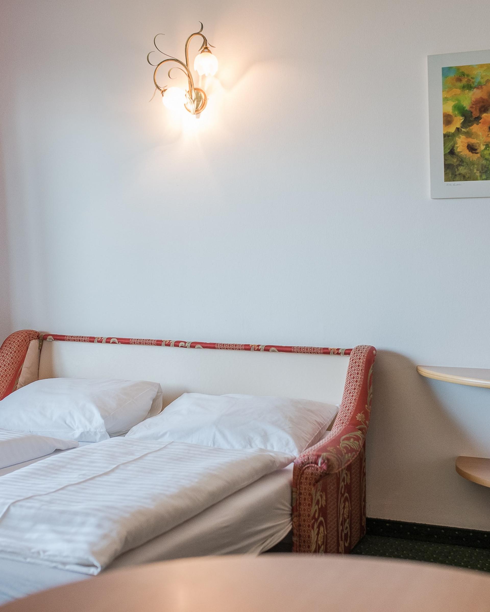 Gemütliches Doppelzimmer mit Alpenpalais Kröll Stil und Sonnenblumenbild