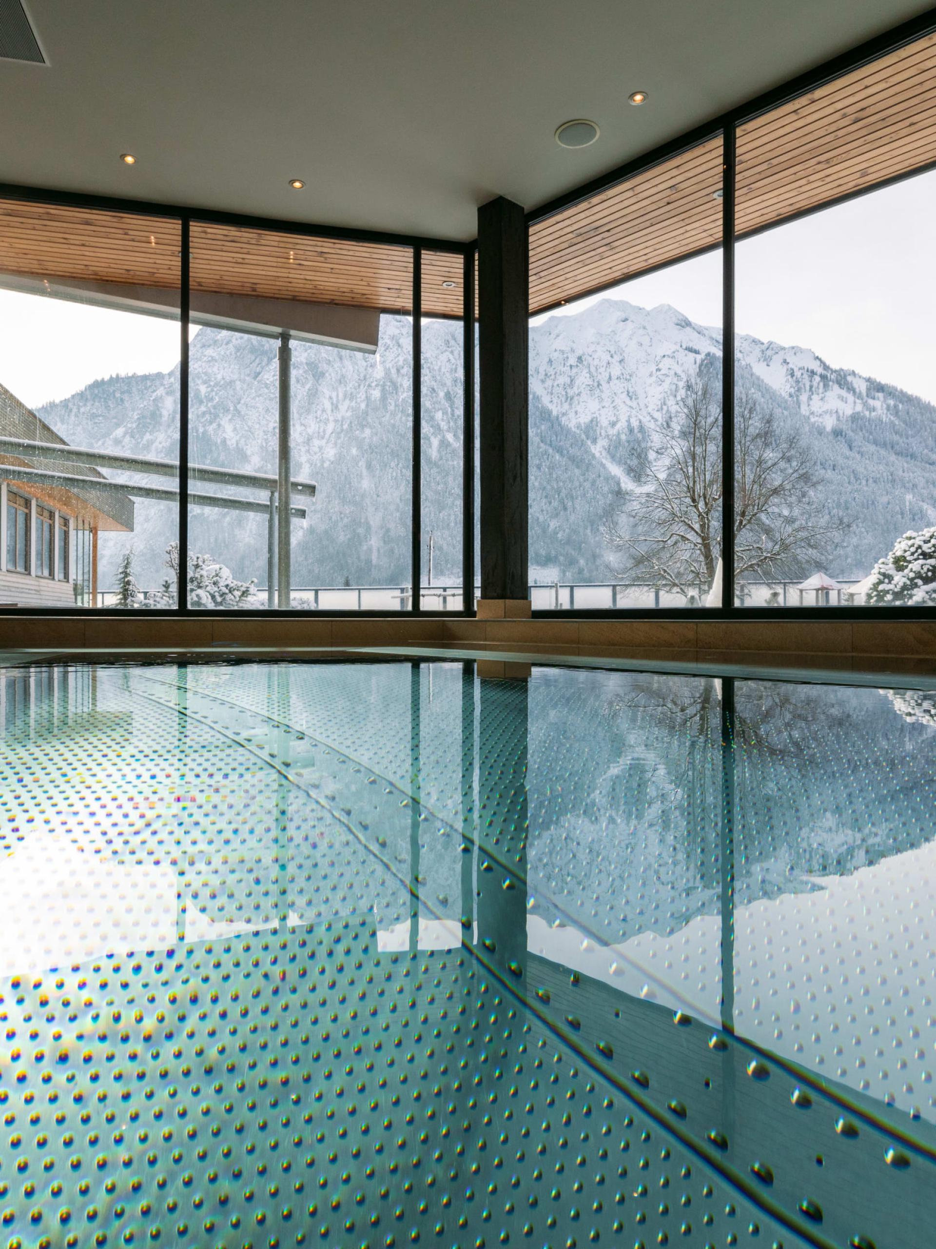 Indoor pool at Familienresort Buchau with mountain view through large windows
