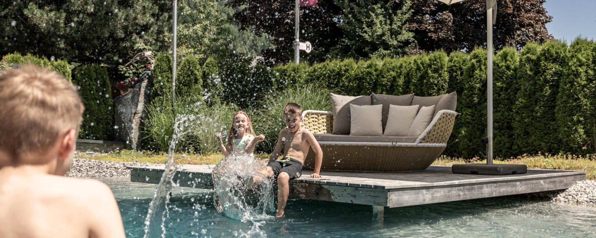 Kinder spielen am Pool des Hotel Gassner **** Superior an einem sonnigen Tag