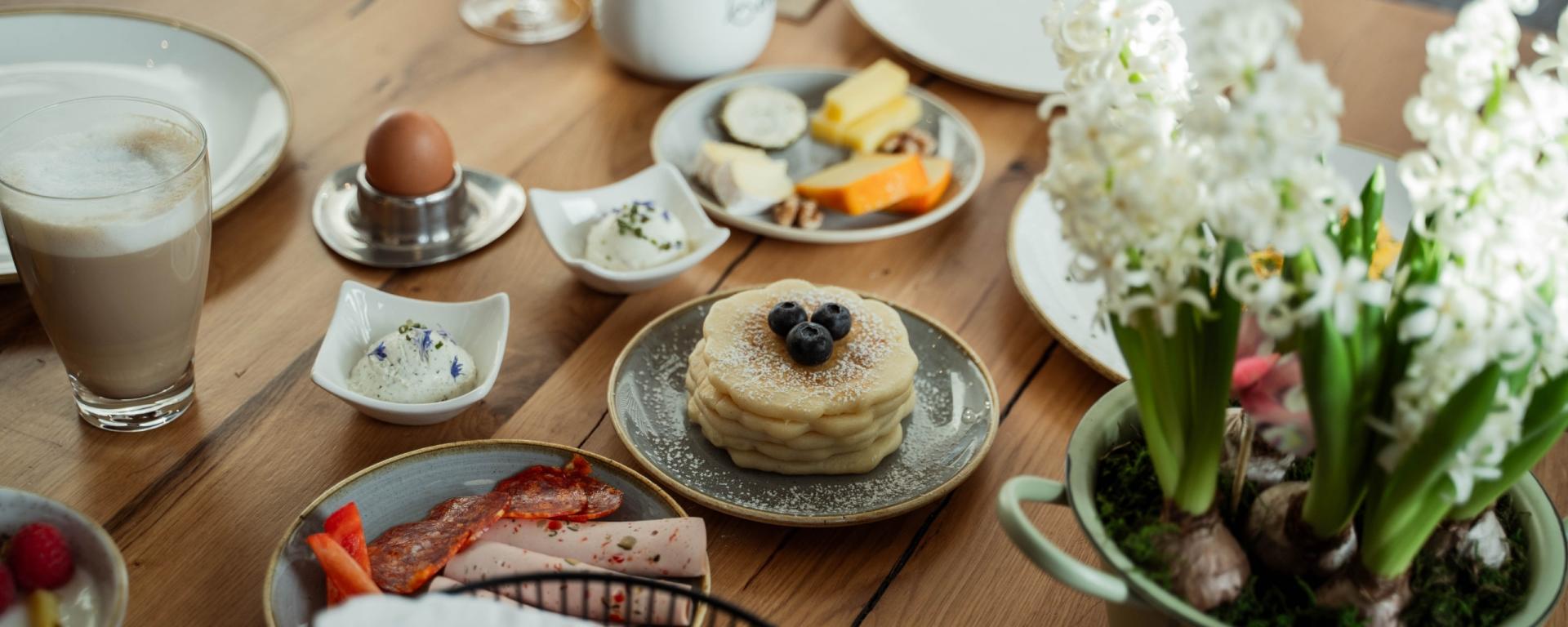 Frühstückstisch mit Eiern, Käse, Pancakes und Kaffee im Hotel Gassner **** Superior