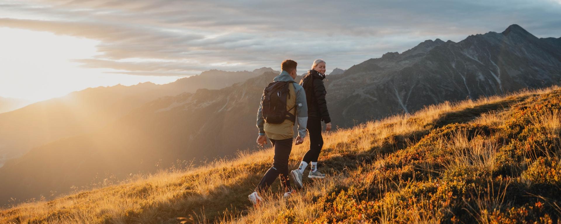 Hotel Gassner **** Superior Gäste wandern im Sonnenuntergang in den Bergen