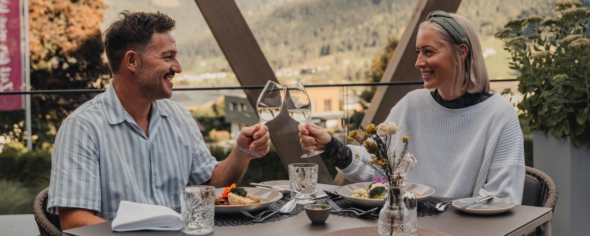 Paar stößt auf Terrasse des Hotel Gassner **** Superior an