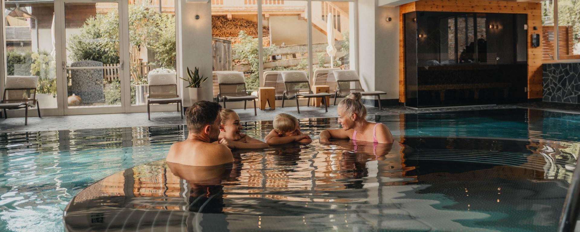 Familie entspannt im Innenpool des Hotel Gassner **** Superior
