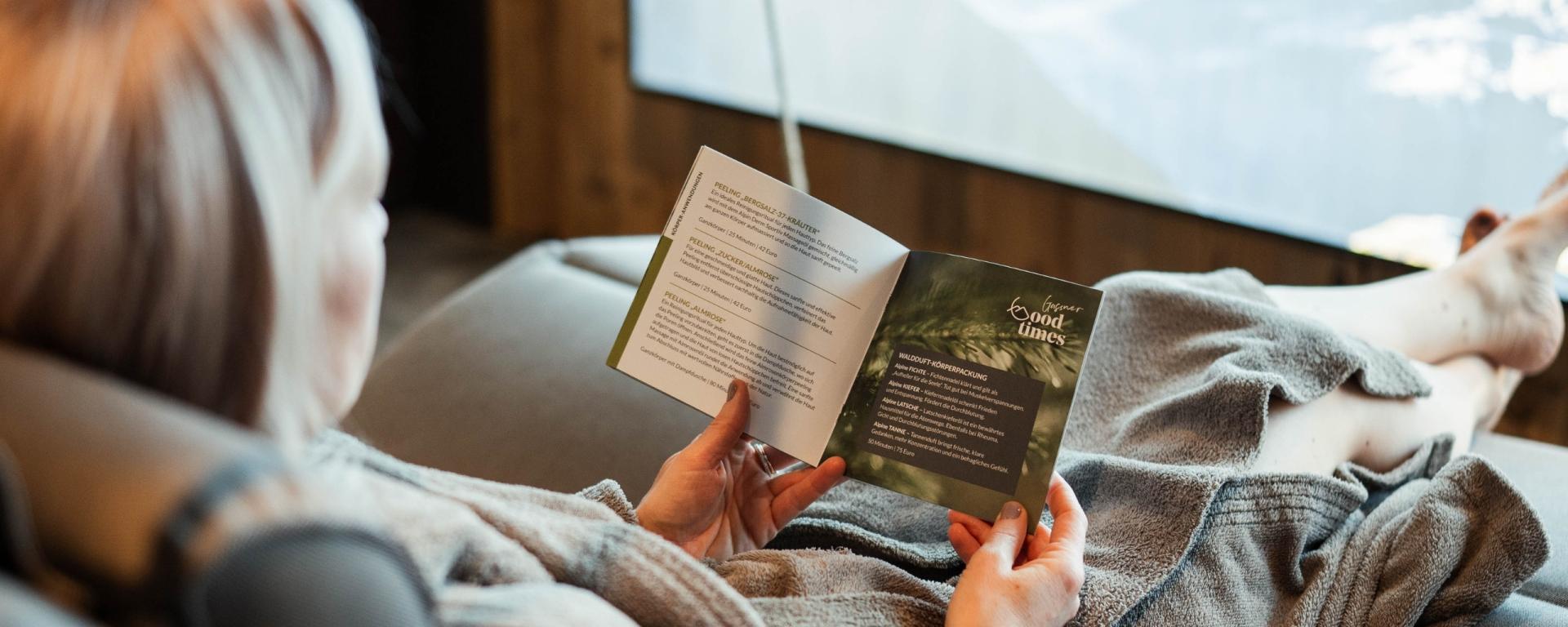 Gästin liest entspannt Buch im Hotel Gassner **** Superior mit Bergblick