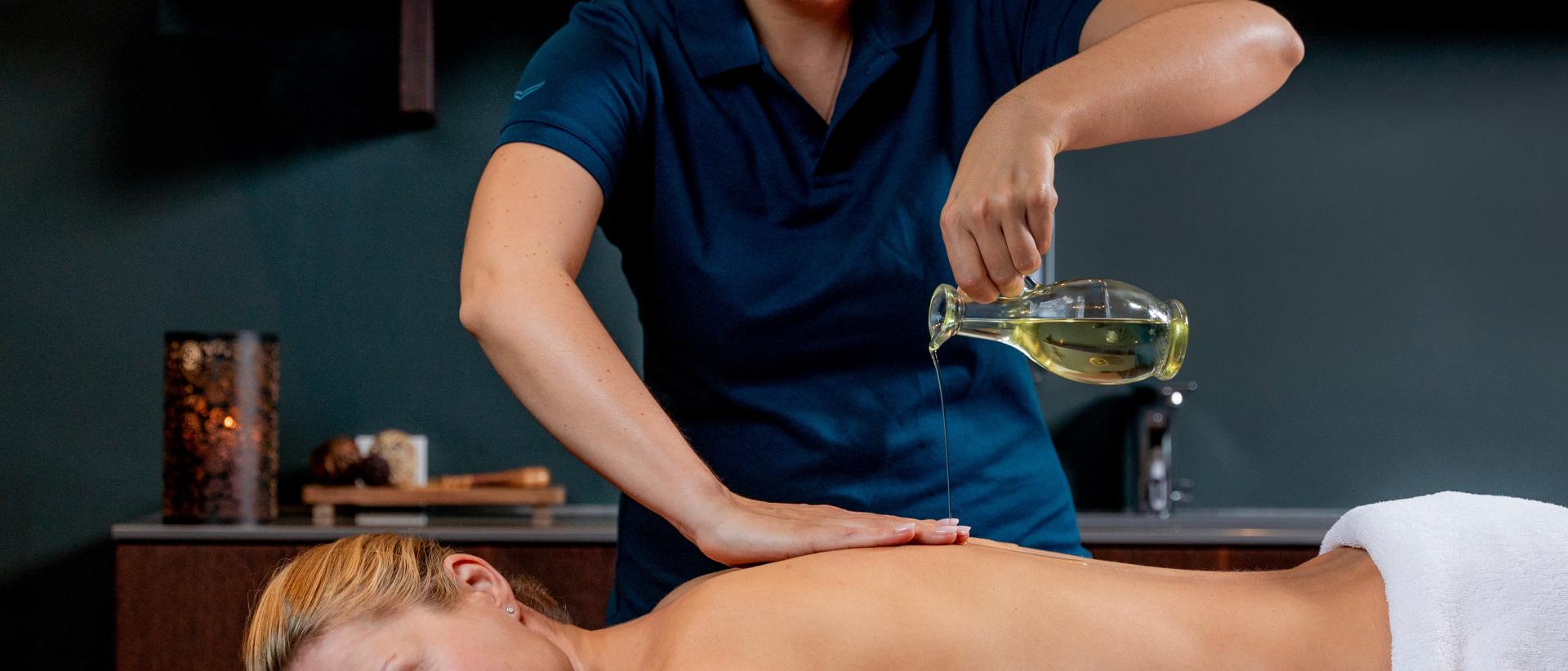 Eine Frau bekommet eine Abhyanga MAssage mit Ölguss