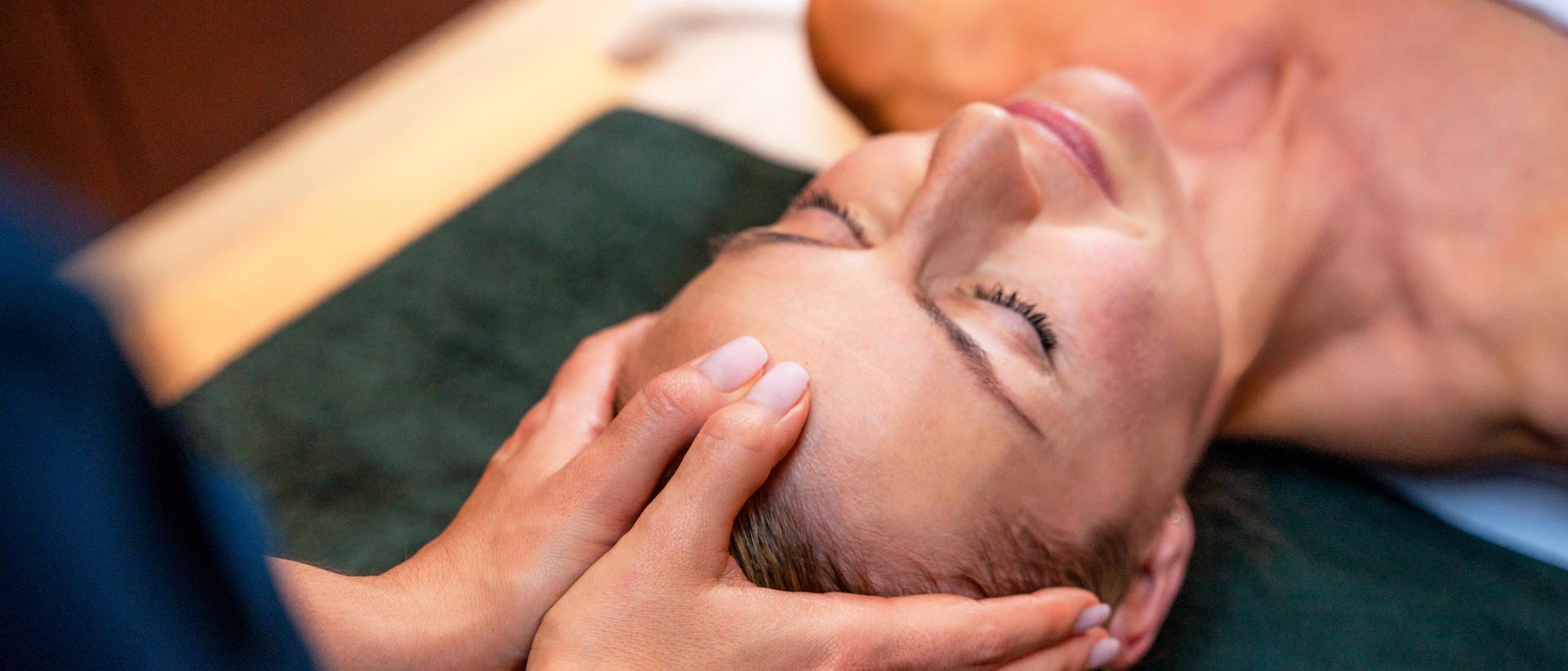 Frau wird am Kopf massiert