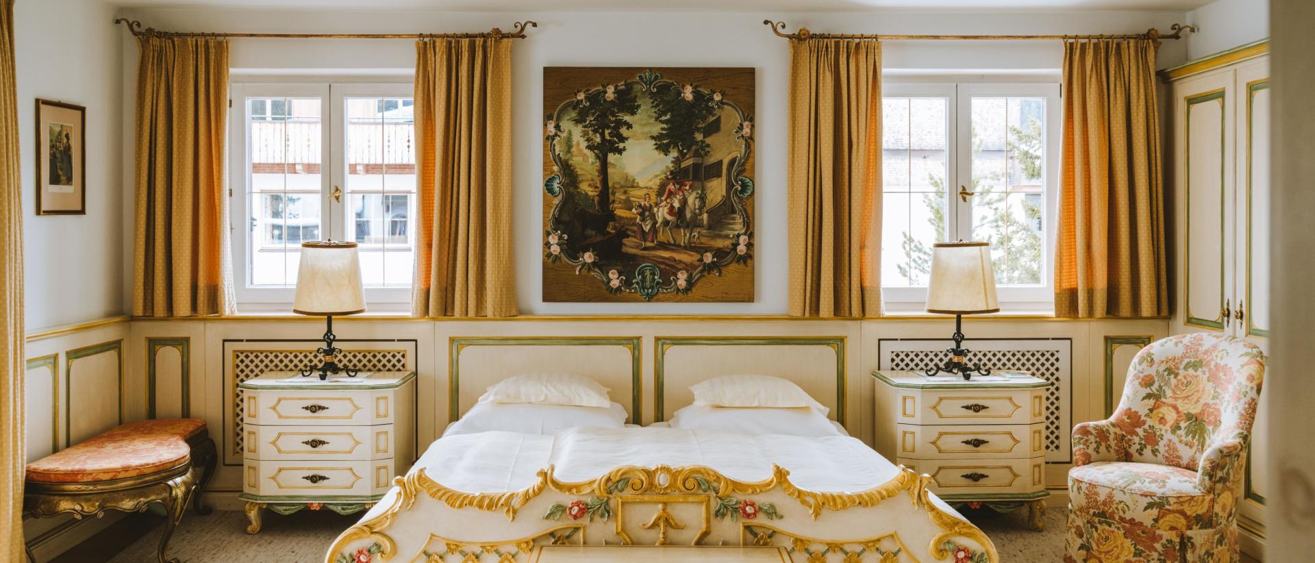 Elegantes Doppelzimmer im Hotel Post Lech mit zwei Betten und floralem Interieur