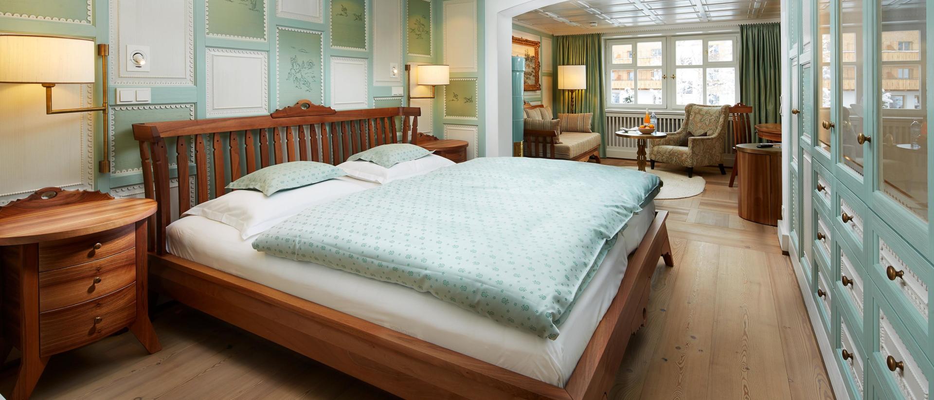 Elegantes Schlafzimmer im Hotel Post Lech mit Doppelbett und Sitzecke