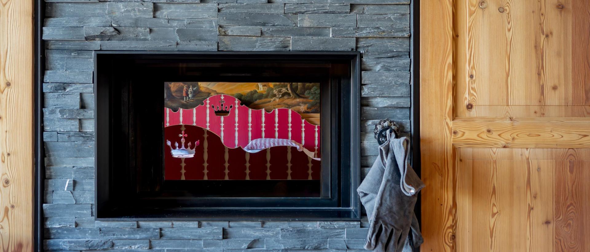 Hotel Post Lech: Black fireplace set in a slate wall beside a wooden door