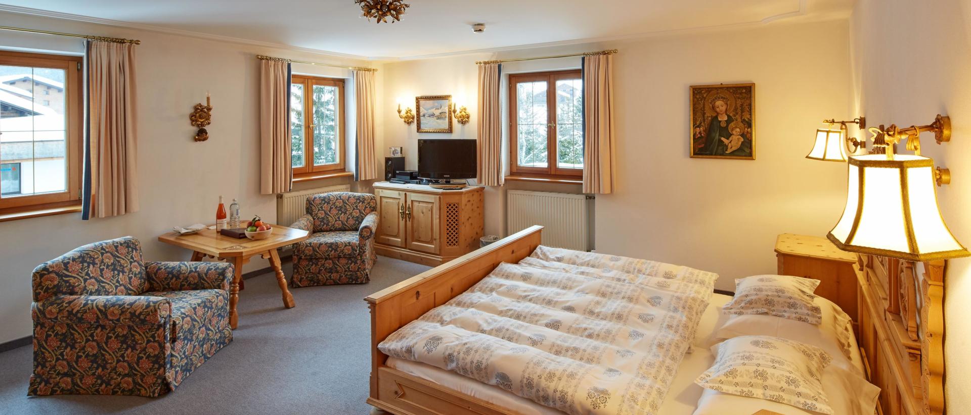 Hotel Post Lech: Gemütliches Schlafzimmer mit Doppelbett und Sitzecke