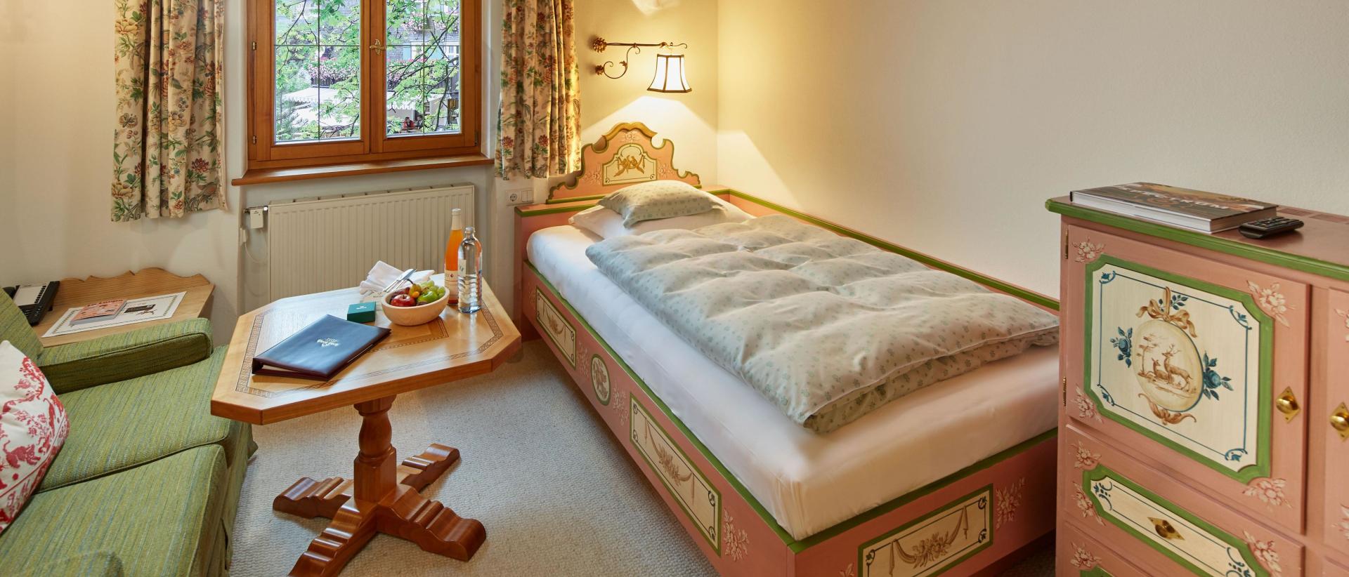 Single room with bed and seating area at Hotel Post Lech