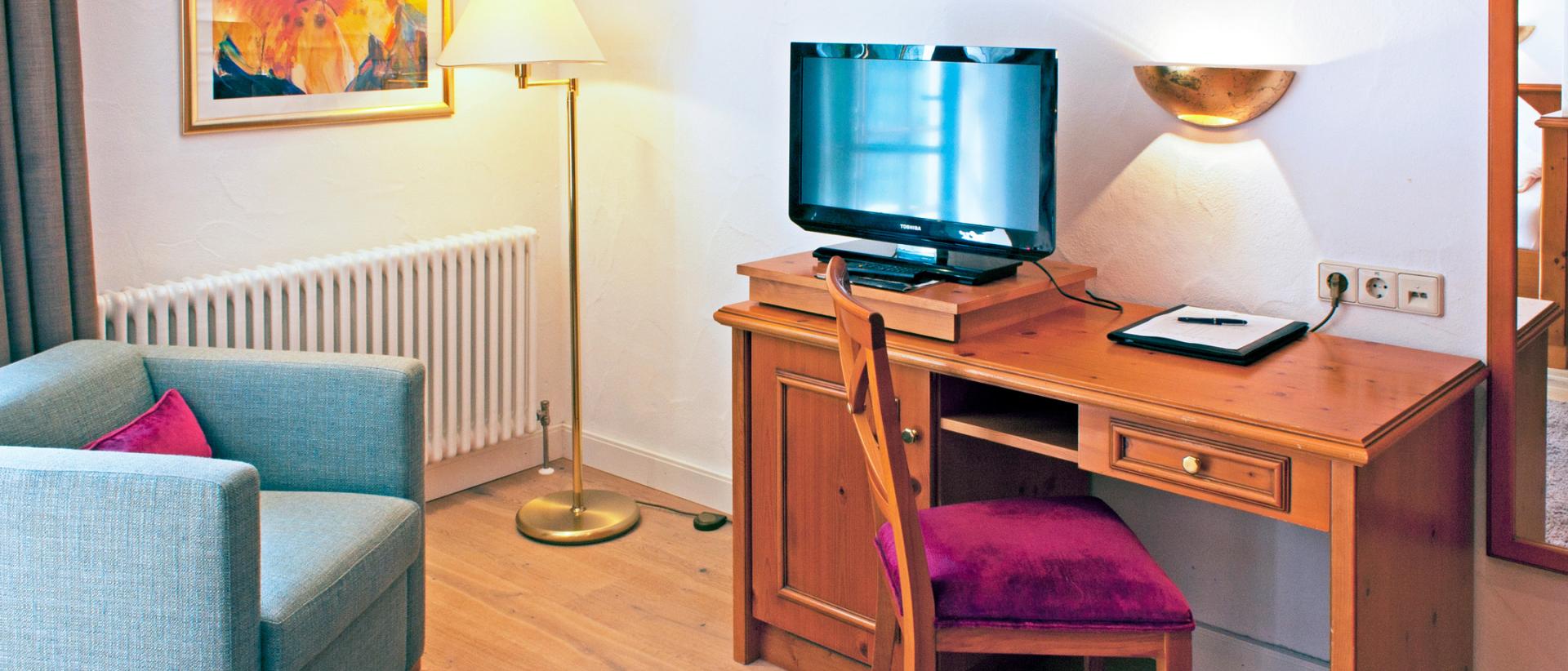 Cozy room view with TV and seating area at Hotel Bayerischer Hof