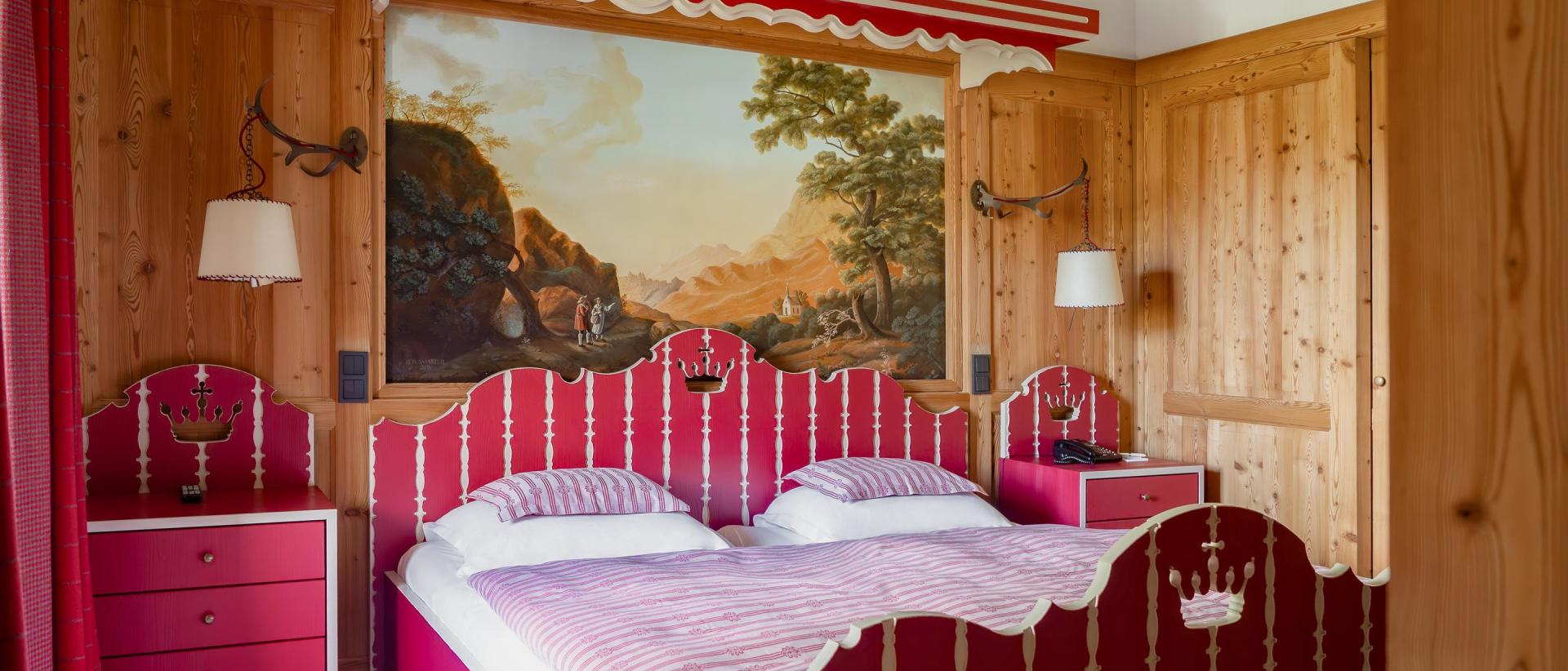 Hotel Post Lech: Red and white double bed in a wood-panelled room