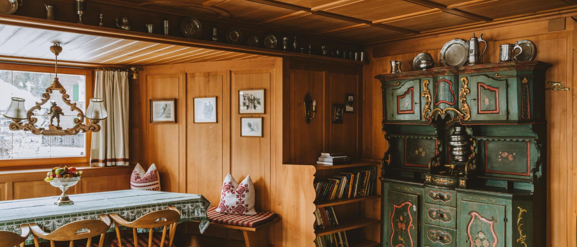 Traditionelle Holzstube mit Esstisch und grünem Bauernschrank im Hotel Post Lech