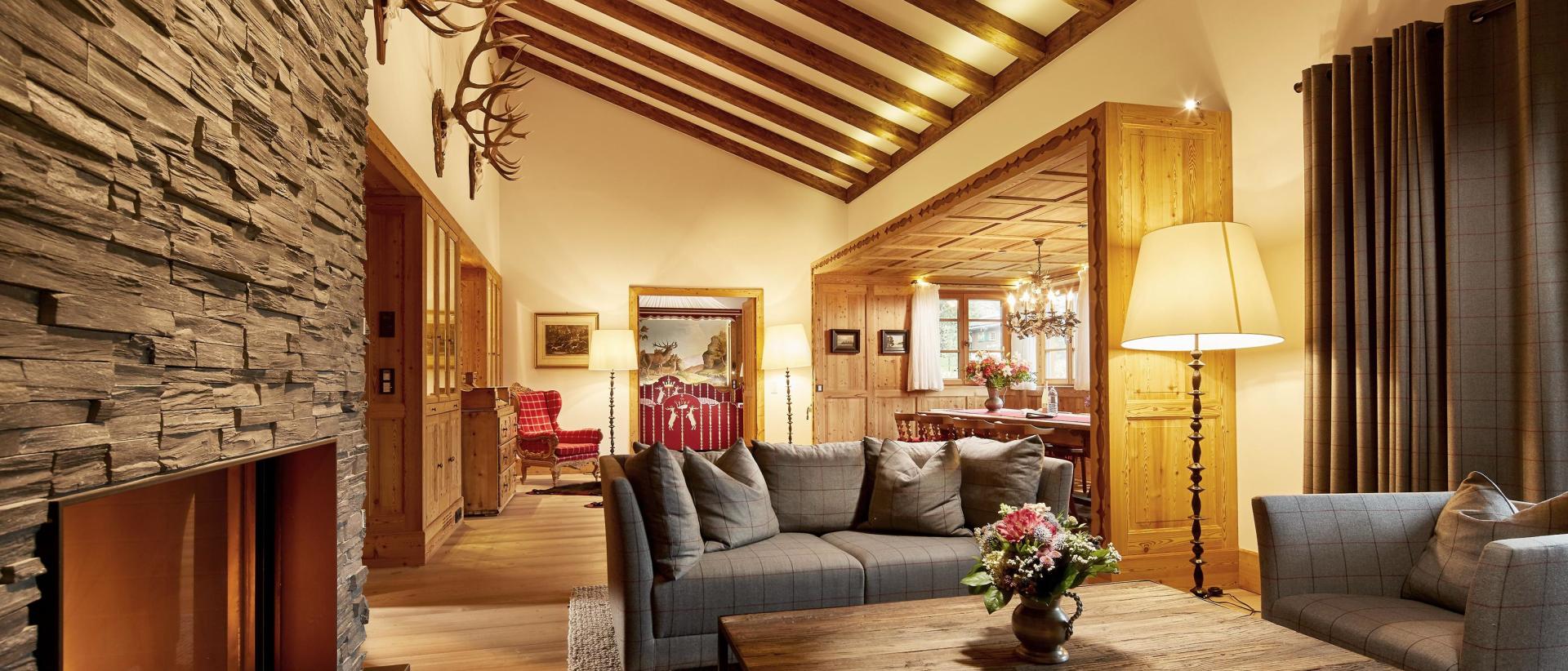 Hotel Post Lech: Gemütliche Lounge mit Kamin, Sofas und Holzbalkendecke