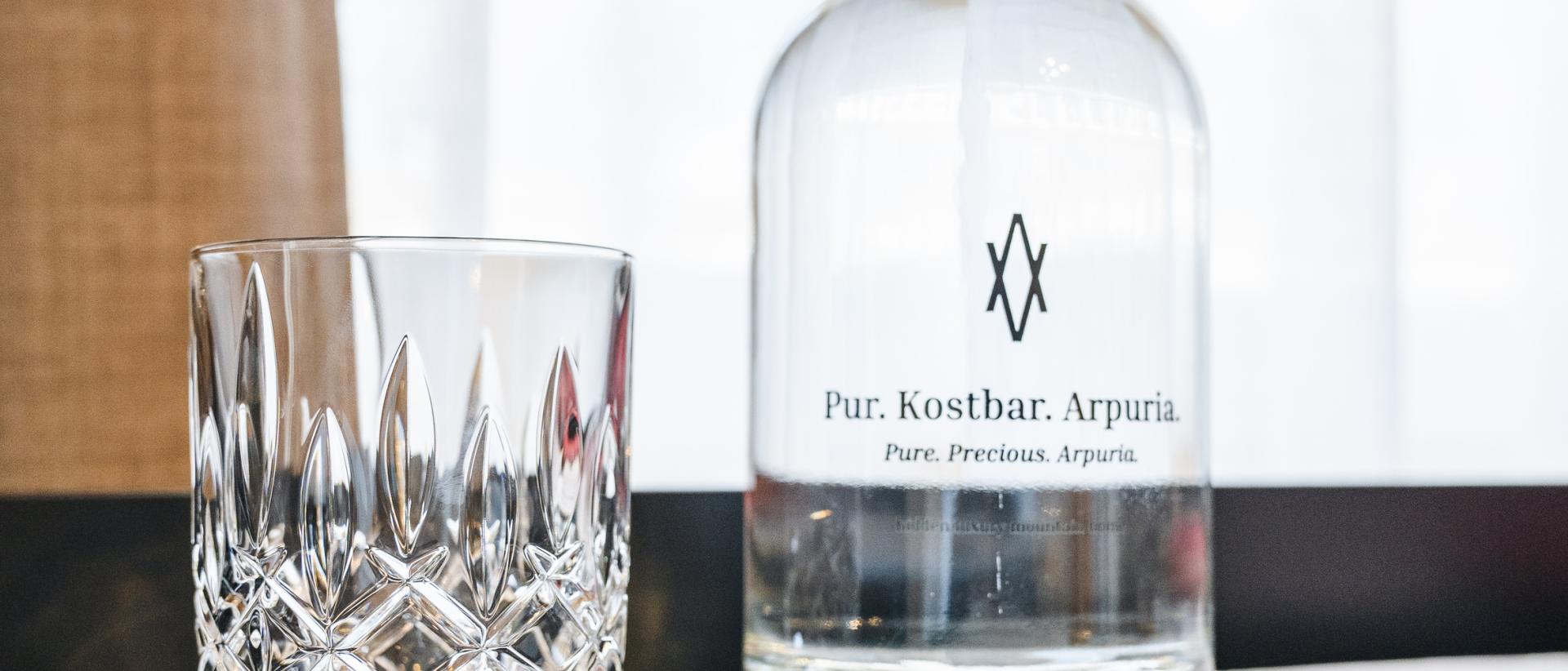 Glas und Wasserflasche im Hotel Arpuria auf einem Tisch