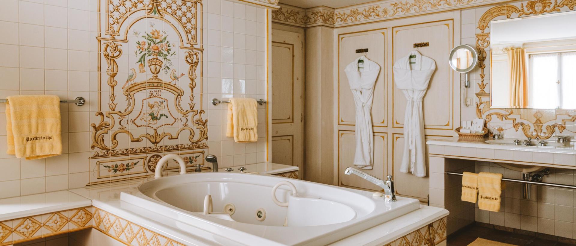 Hotel Post Lech: Badezimmer mit Whirlpool und floralen Fliesenornamenten
