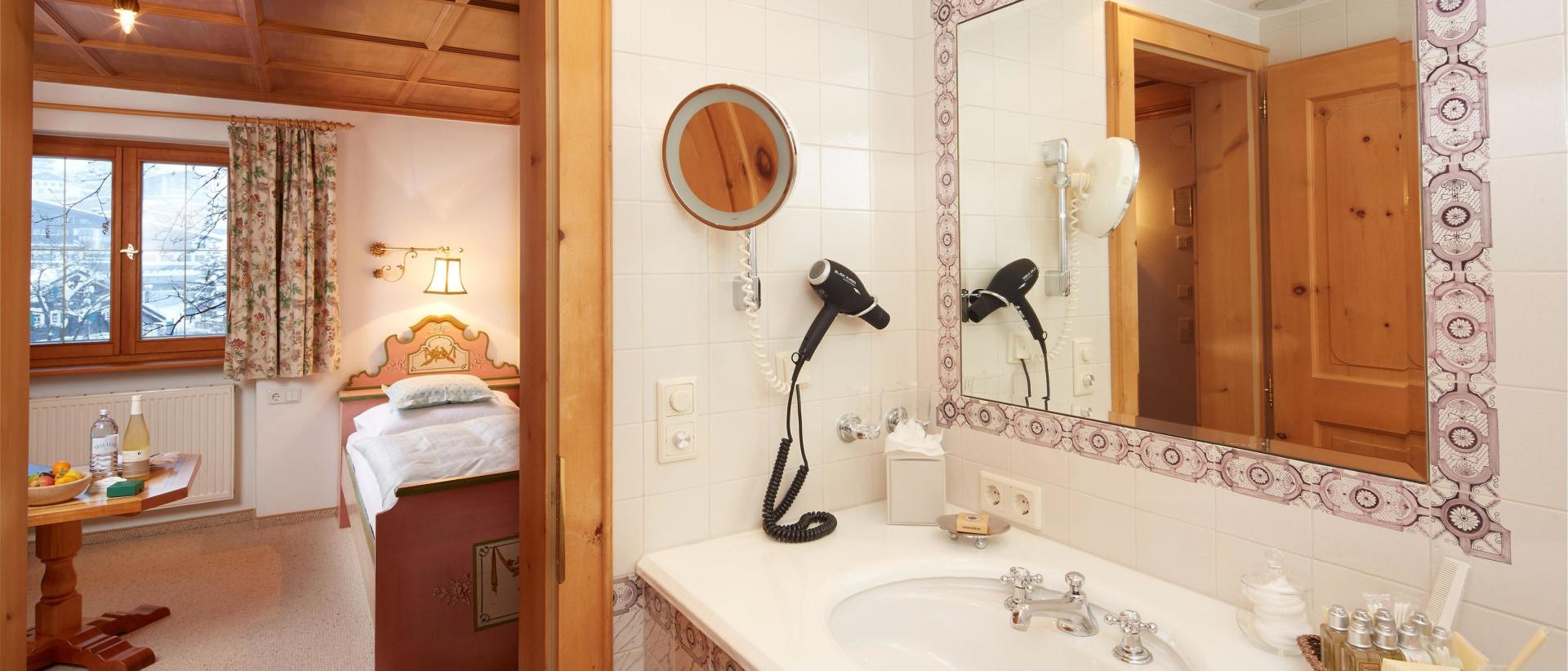 Bathroom with sink at Hotel Post Lech beside a bedroom