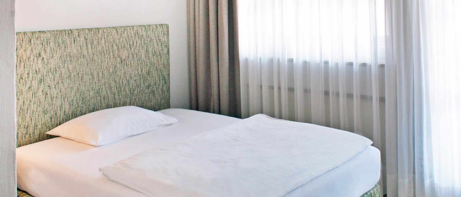 Hotel Bayerischer Hof single room with green bed and white bedding
