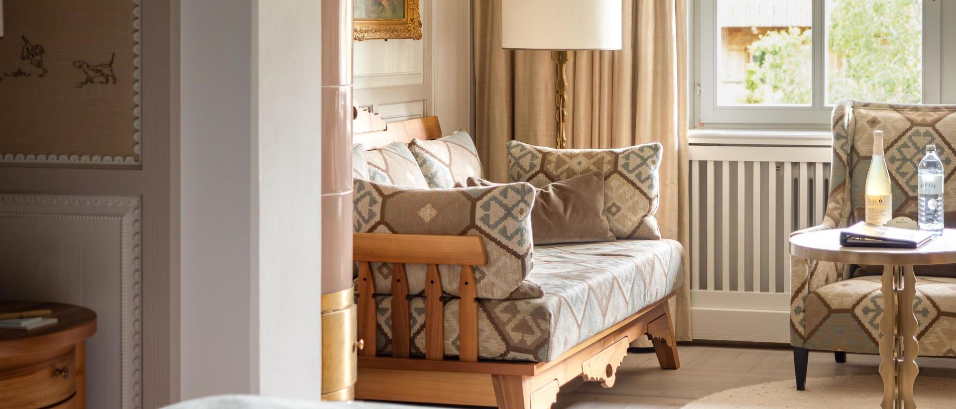 Wohnbereich im Hotel Post Lech mit Sofa, Sessel, Tisch und Fenster