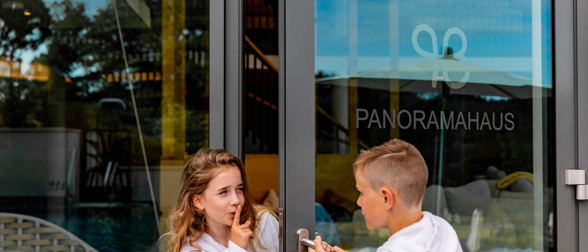 Kinder öffnen die Tür zum Pfalzblick Wald Spa Resort Panoramahaus