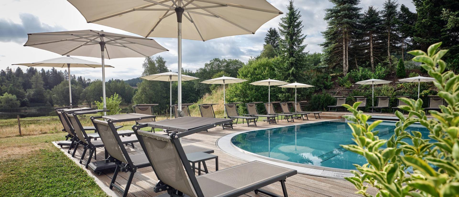 Pool mit Liegen und Sonnenschirmen im Hotel Reppert