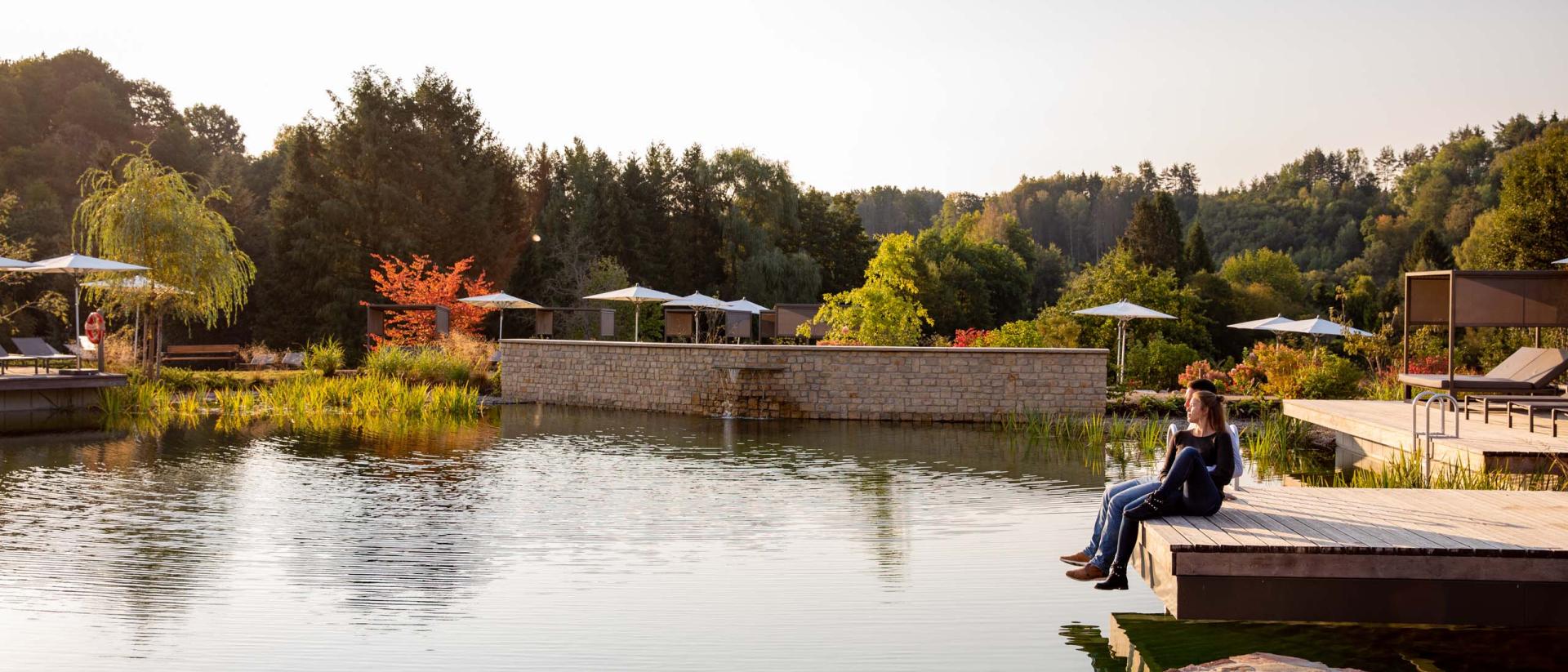 Pfälzblick Wald Spa Resort mit Teich und entspannter Sitzenden in der Natur