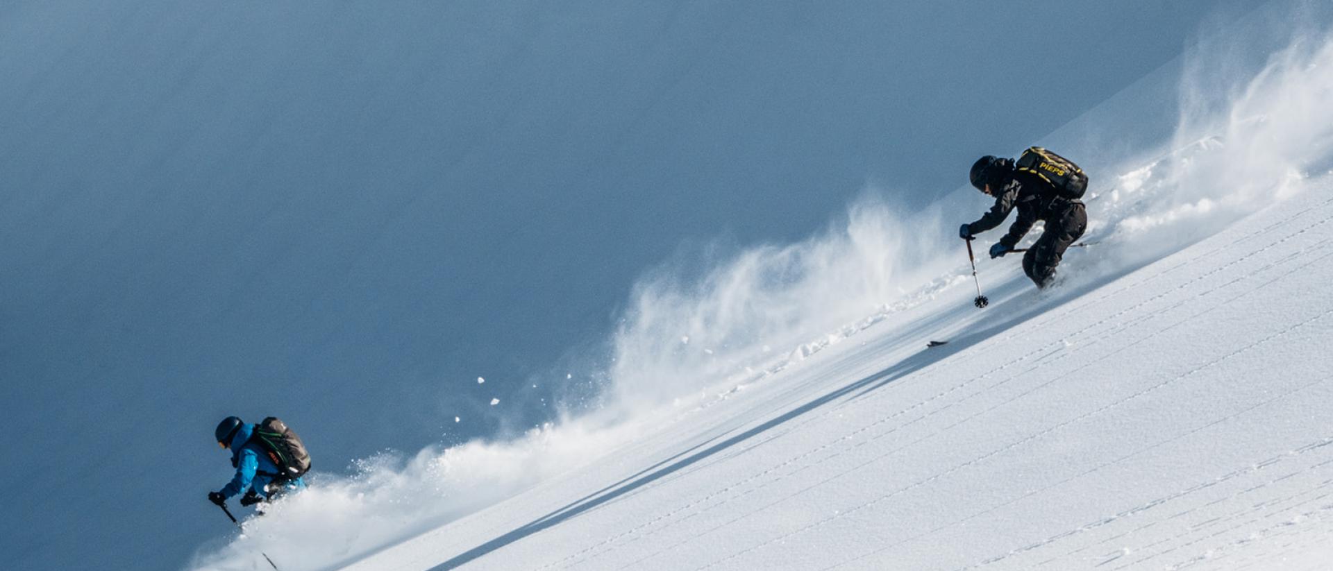 Zwei Skifahrer fahren am Hang mit Schnee bei Hotel Aurora