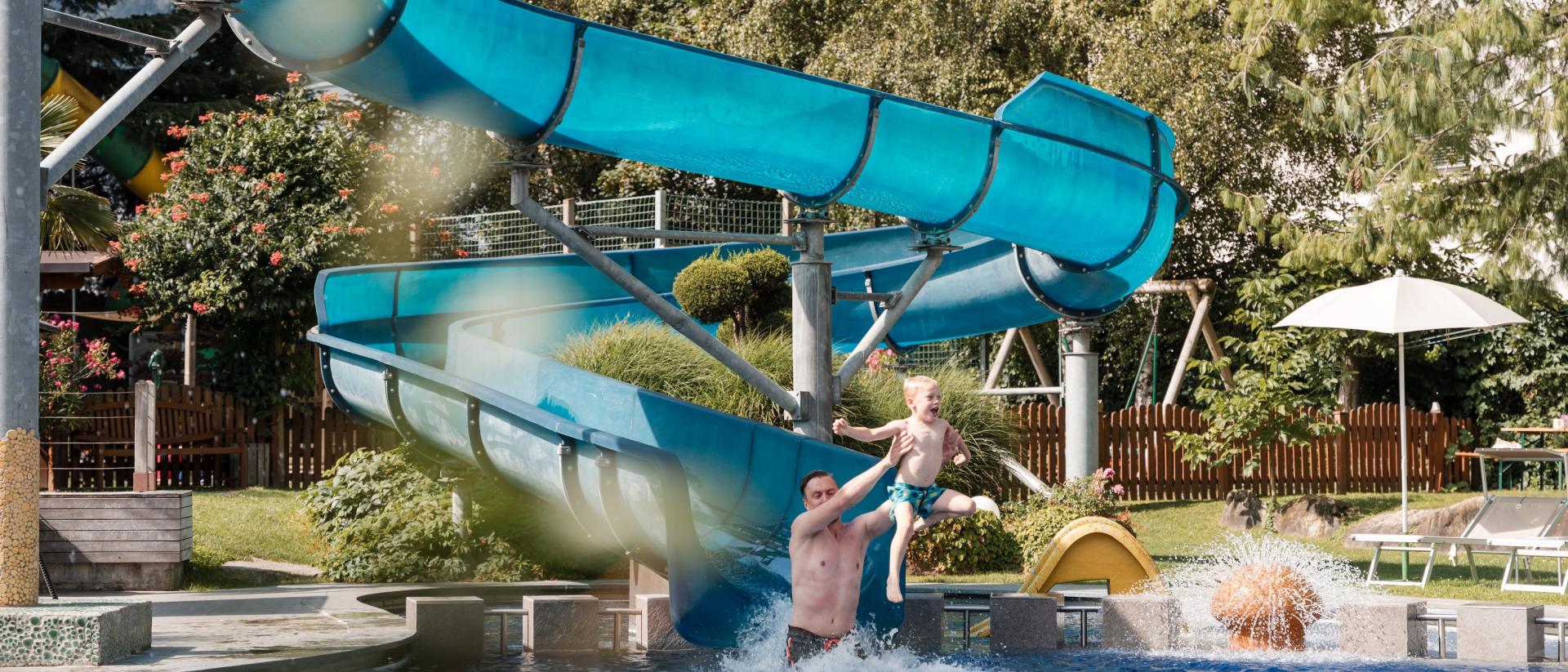 Vater und Sohn rutschen im TYROL Family Retreat.