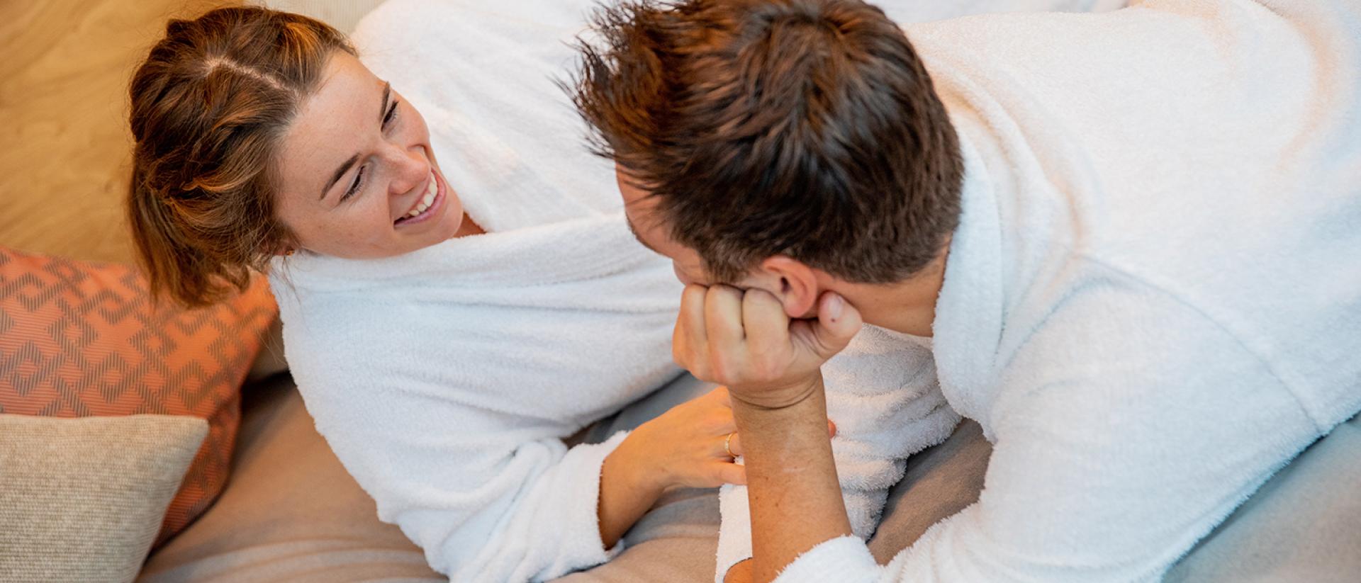 Paar in weißen Bademänteln entspannt im Pfalzblick Wald Spa Resort