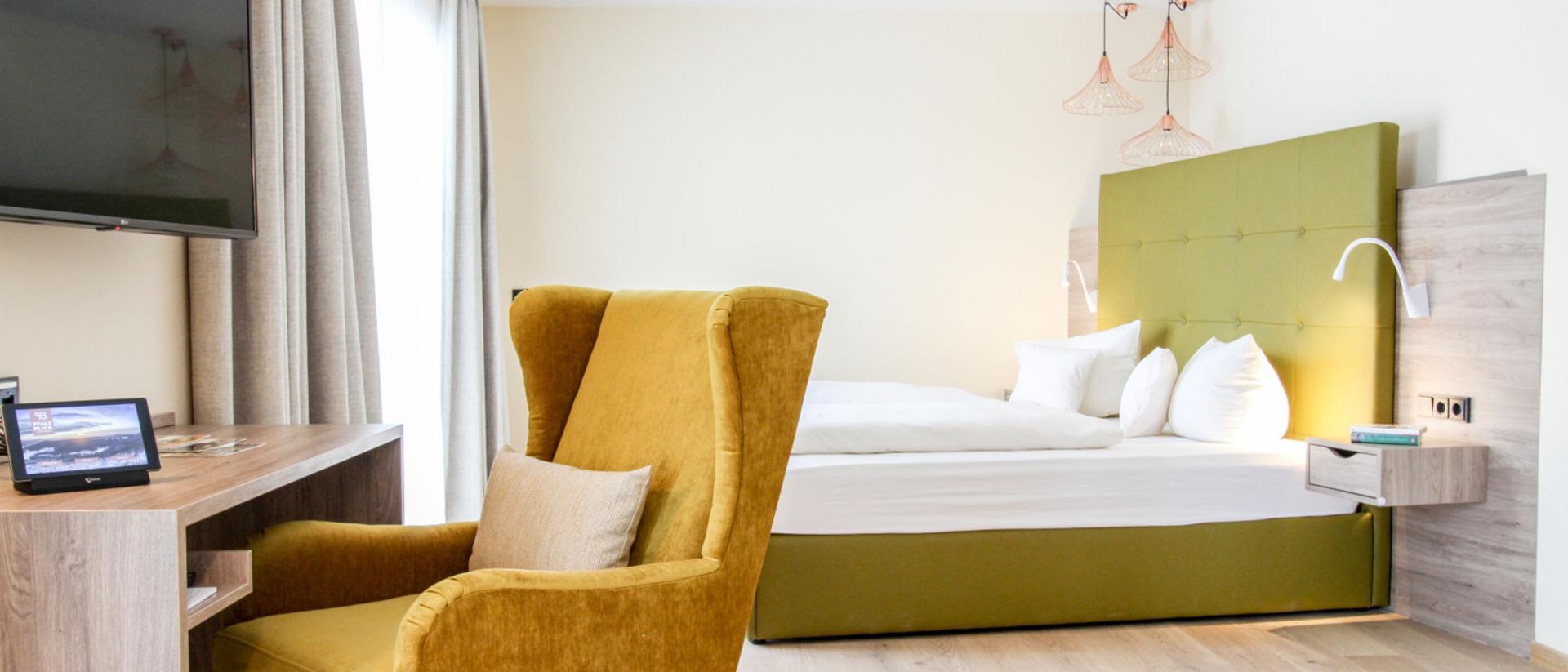 Modernes Zimmer mit gelbem Sessel im Pfalzblick Wald Spa Resort