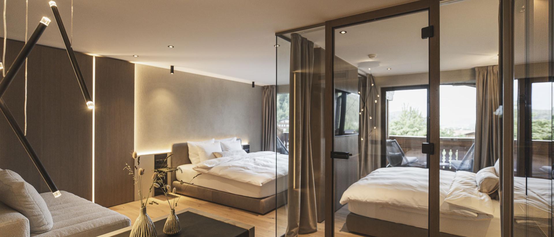 Modernes Zimmer im Hotel Lanerhof mit Glaswand und gemütlichem Bett