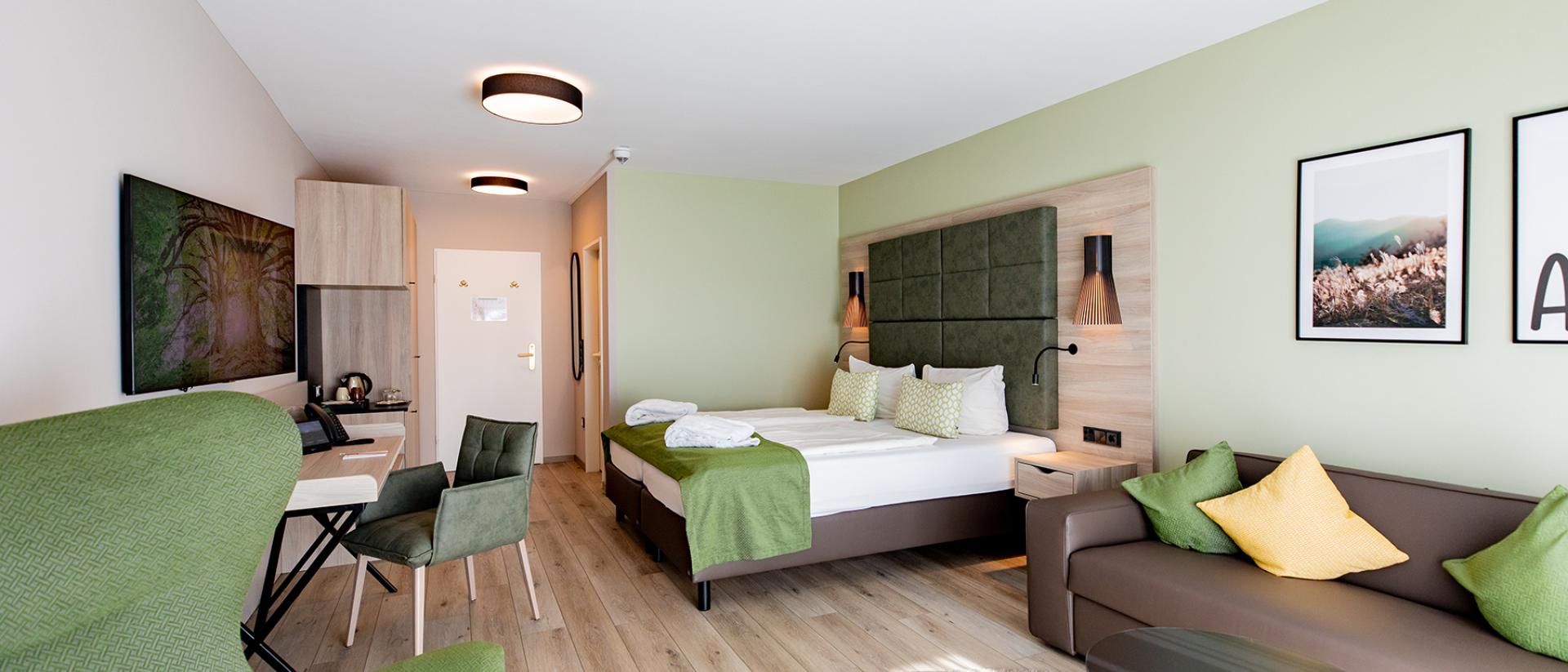 Modernes Hotelzimmer im Pfalzblick Wald Spa Resort mit grünem Interieur